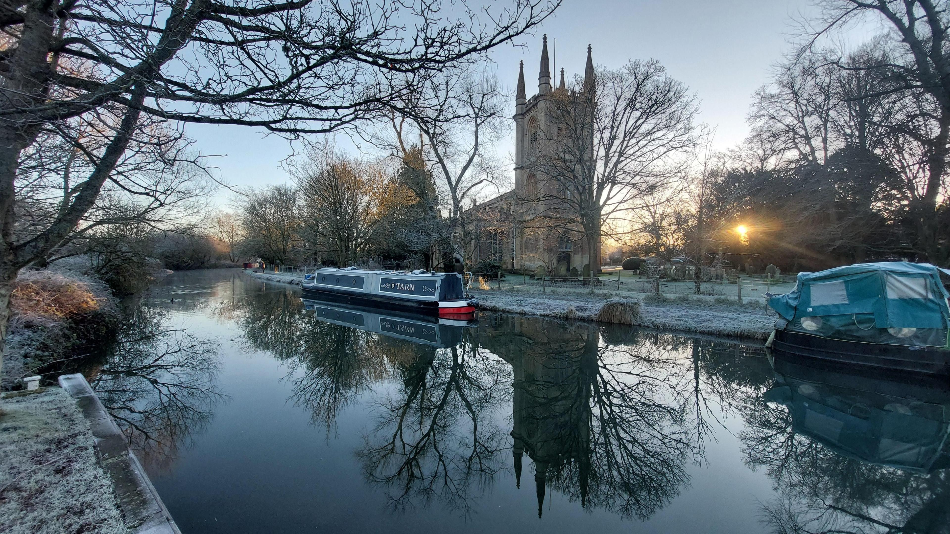 River Thames in Hungerford with views of a navy blue canal boat and the church in the background