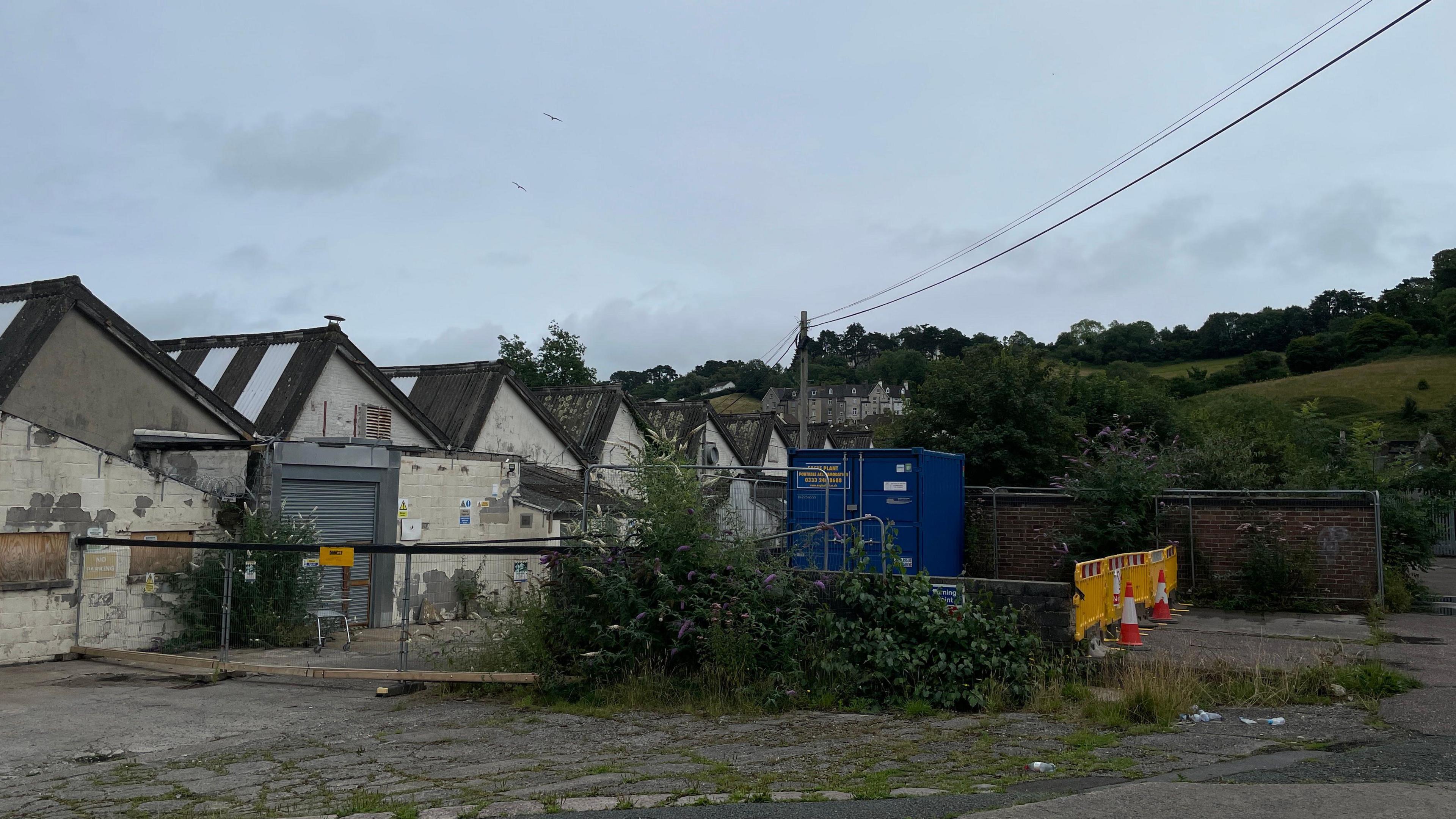 A row of buildings, looking run down, with barriers