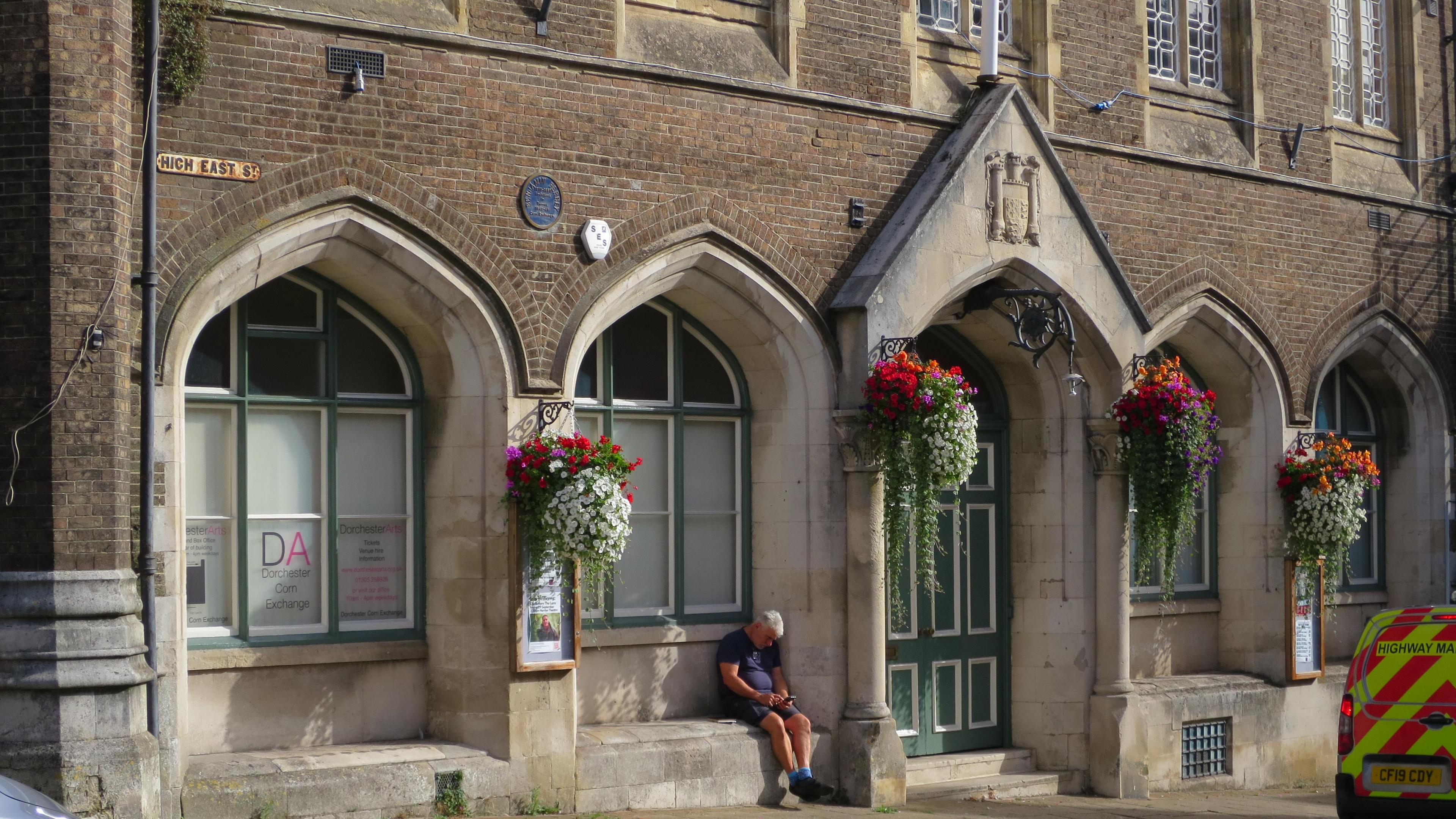 Town council building with hanging baskets of flowers on outside