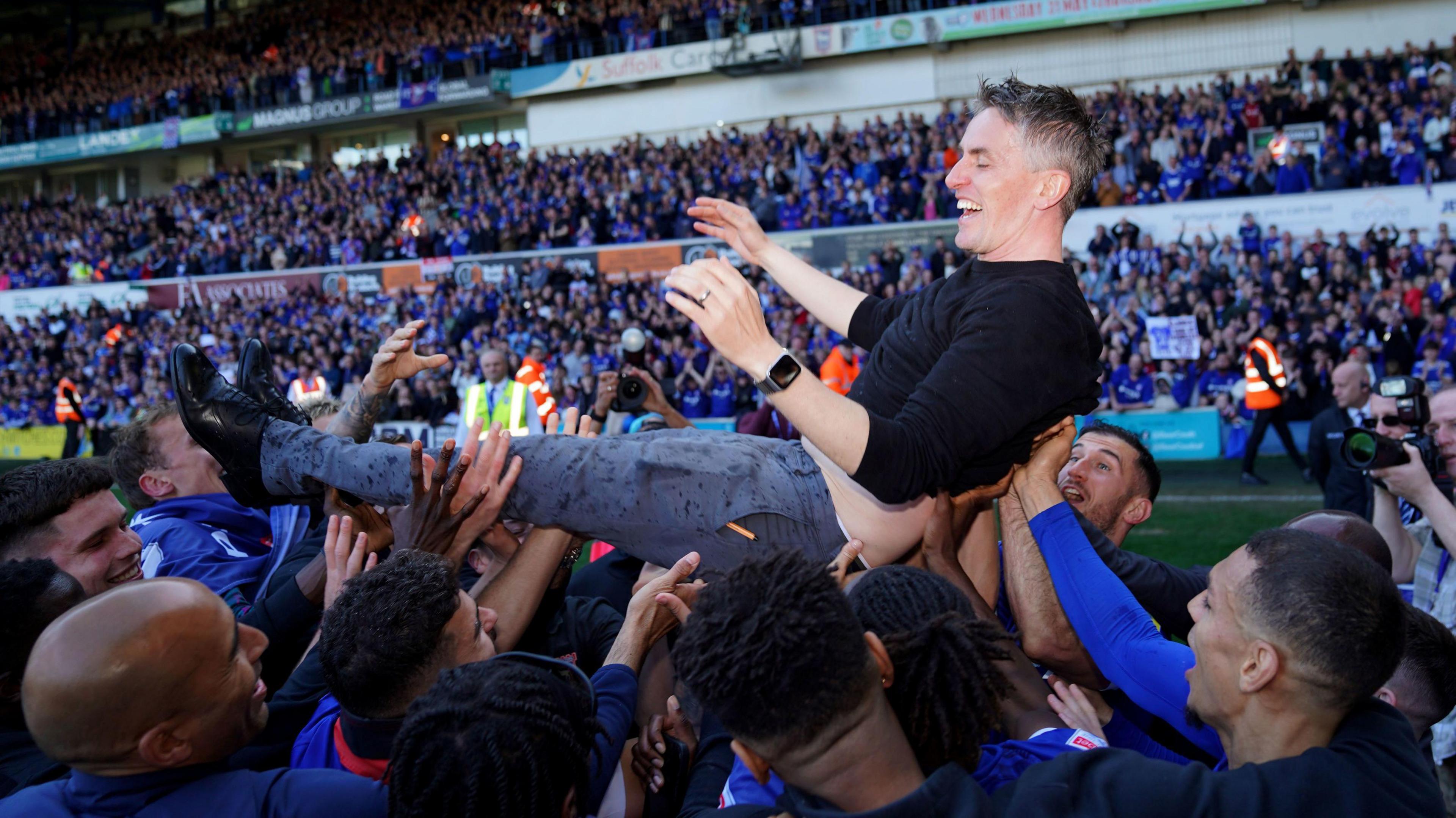 Kieran McKenna is thrown into the air by the Ipswich Town players.