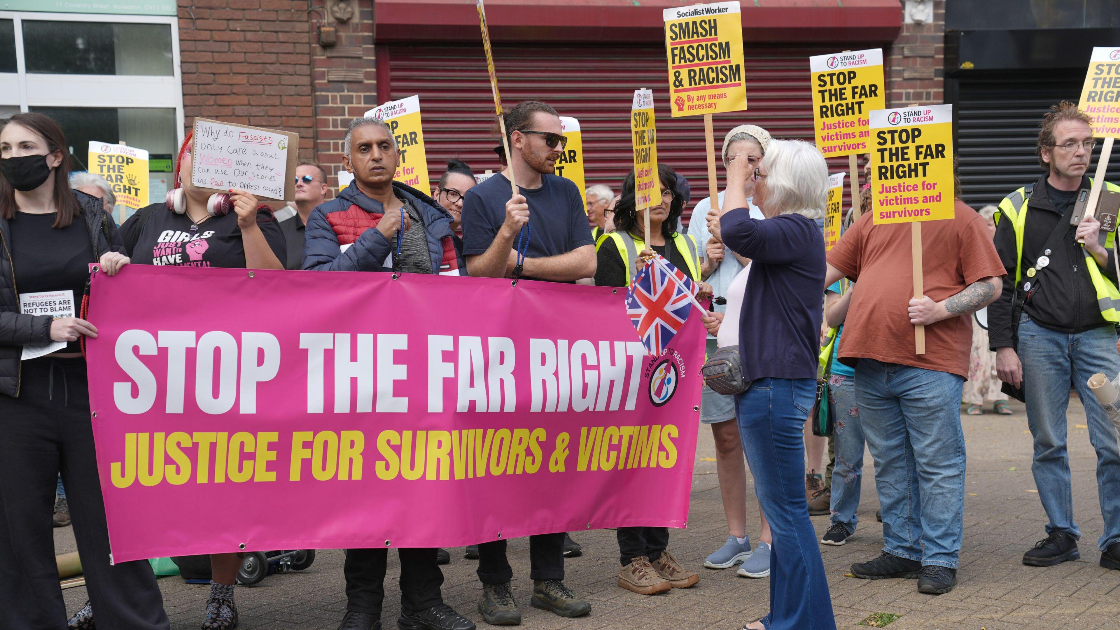 A group of protesters holding a pink banner stating 'stop the far right'