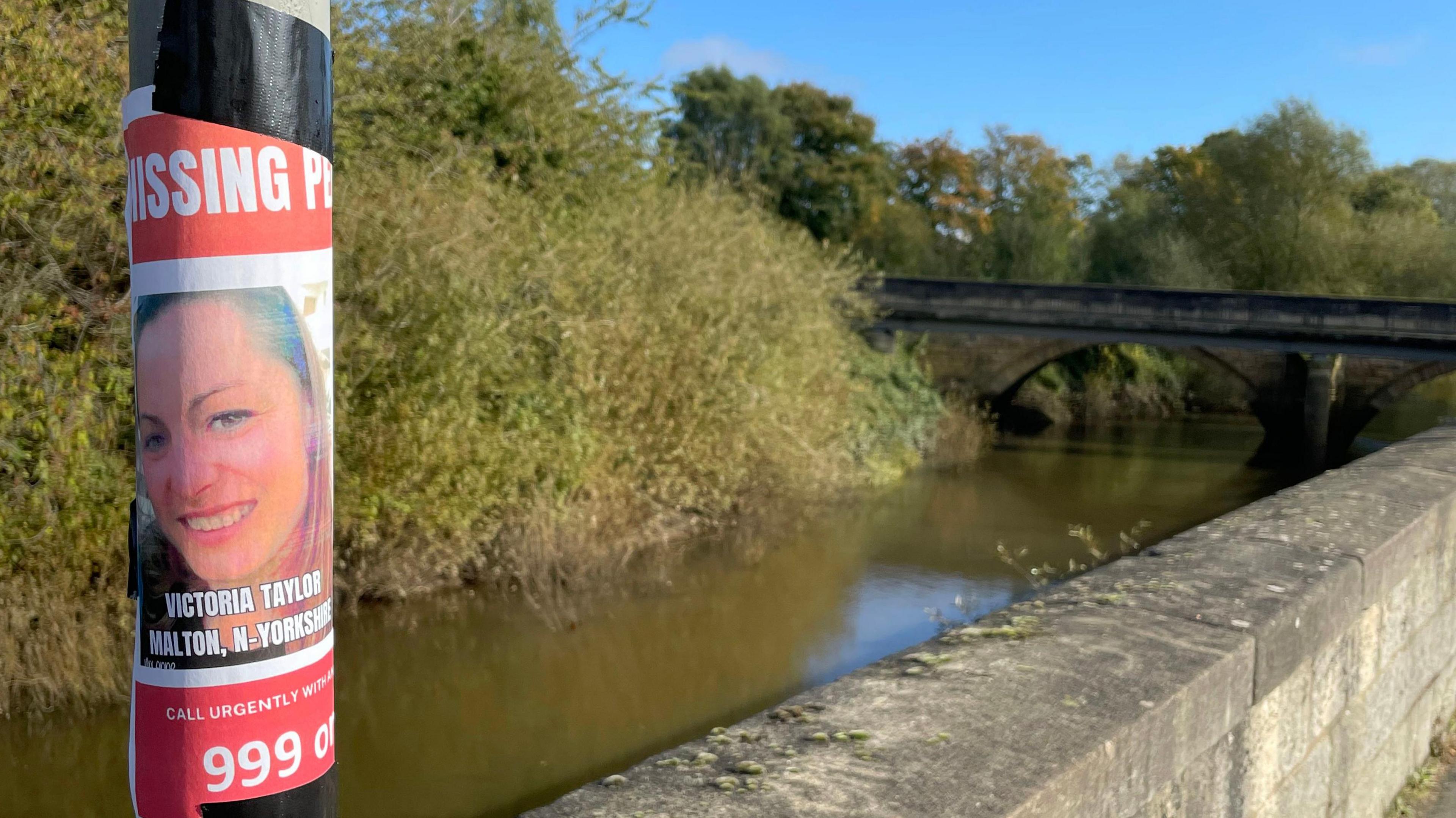 A poster appealing for information regarding missing woman Victoria Taylor on a post next to the River Derwent in Malton