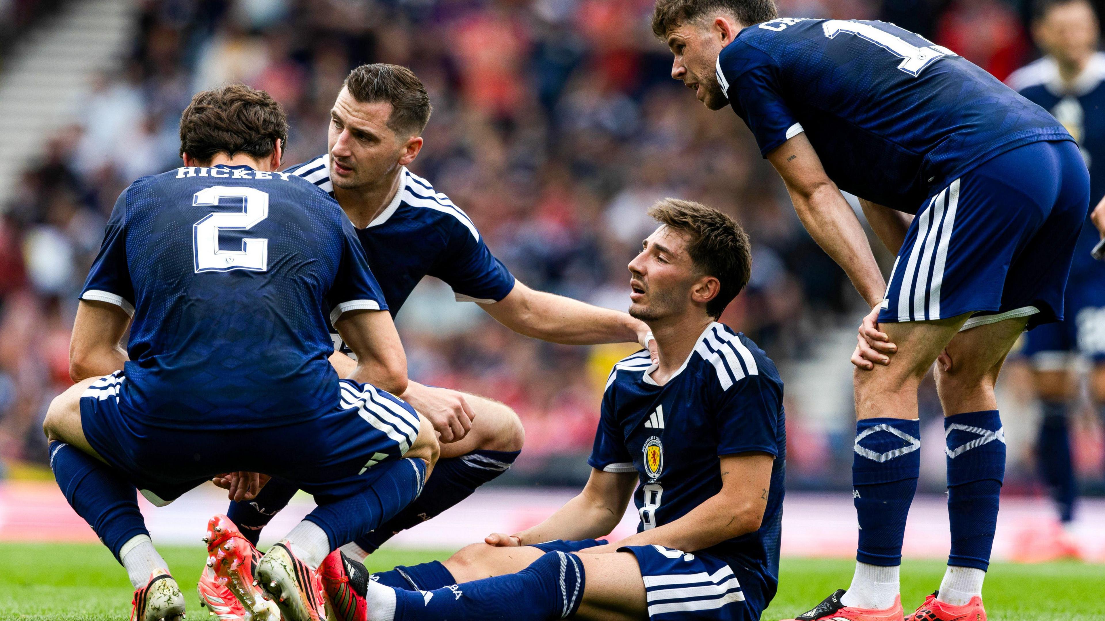 Scotland midfielder Billy Gilmour is comforted by team-mates after picked up an injury