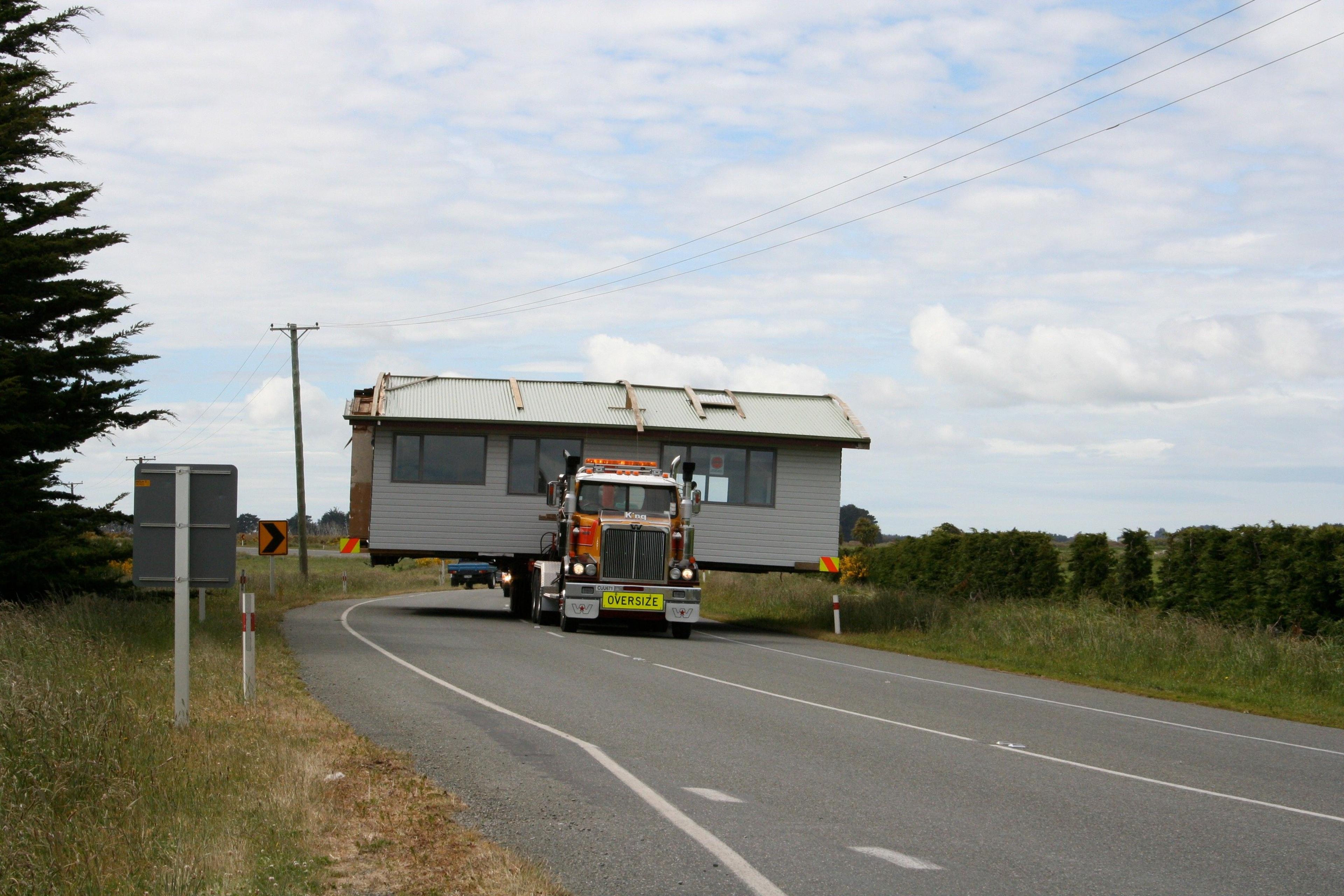 A lorry moves a mobile home along a road