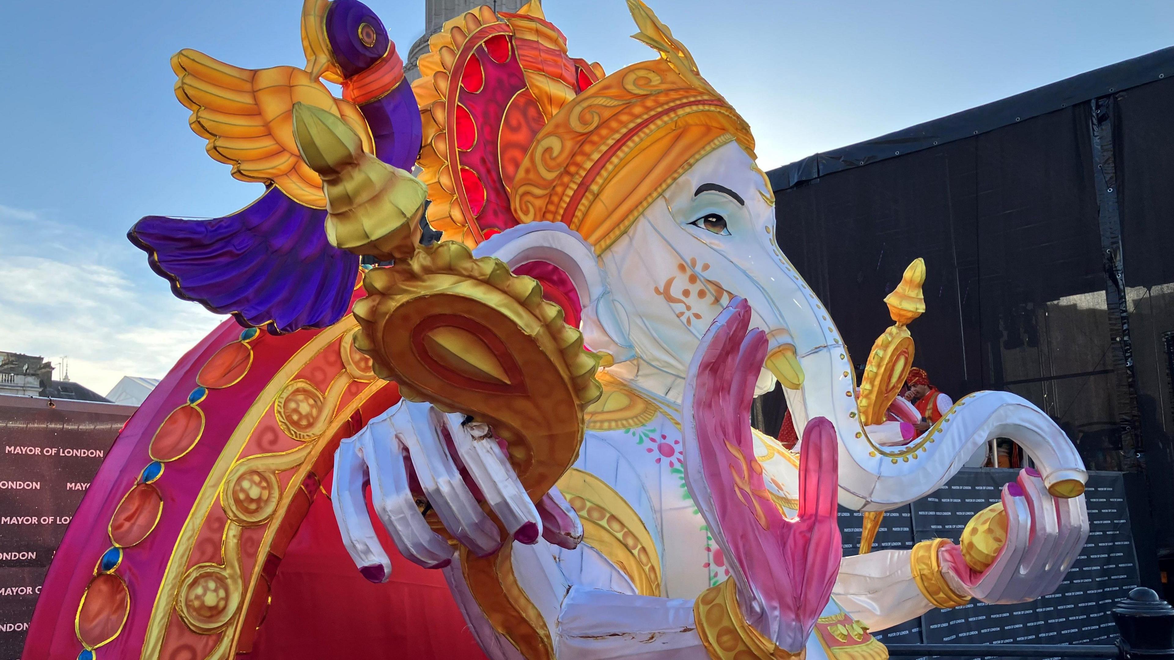 A white, gold and pink inflatable statue of the Hindu God Ganesh, with an elephant head and four arms