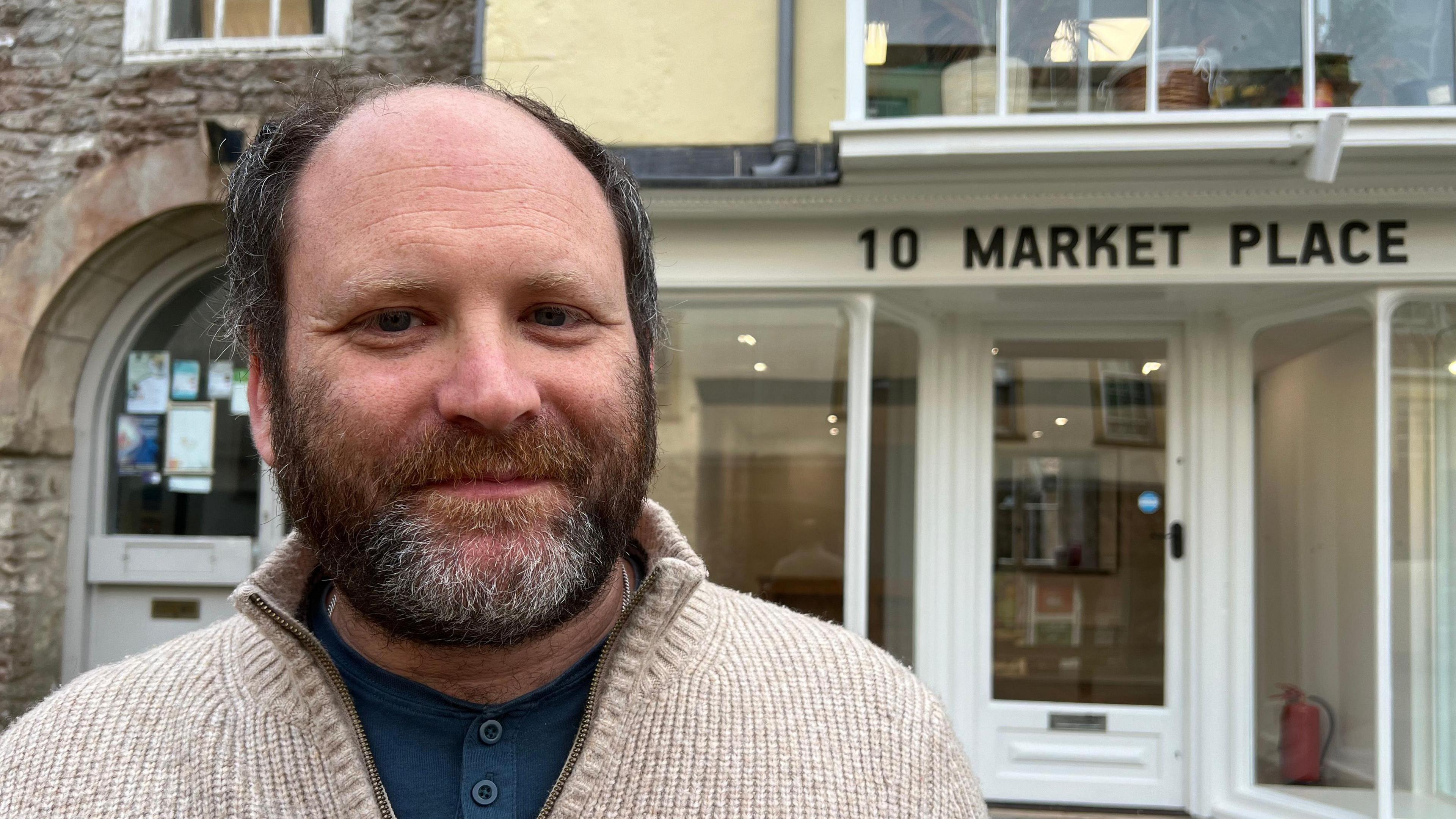 A man stands outside 10 Market Place shop which hosts new shops rent free.