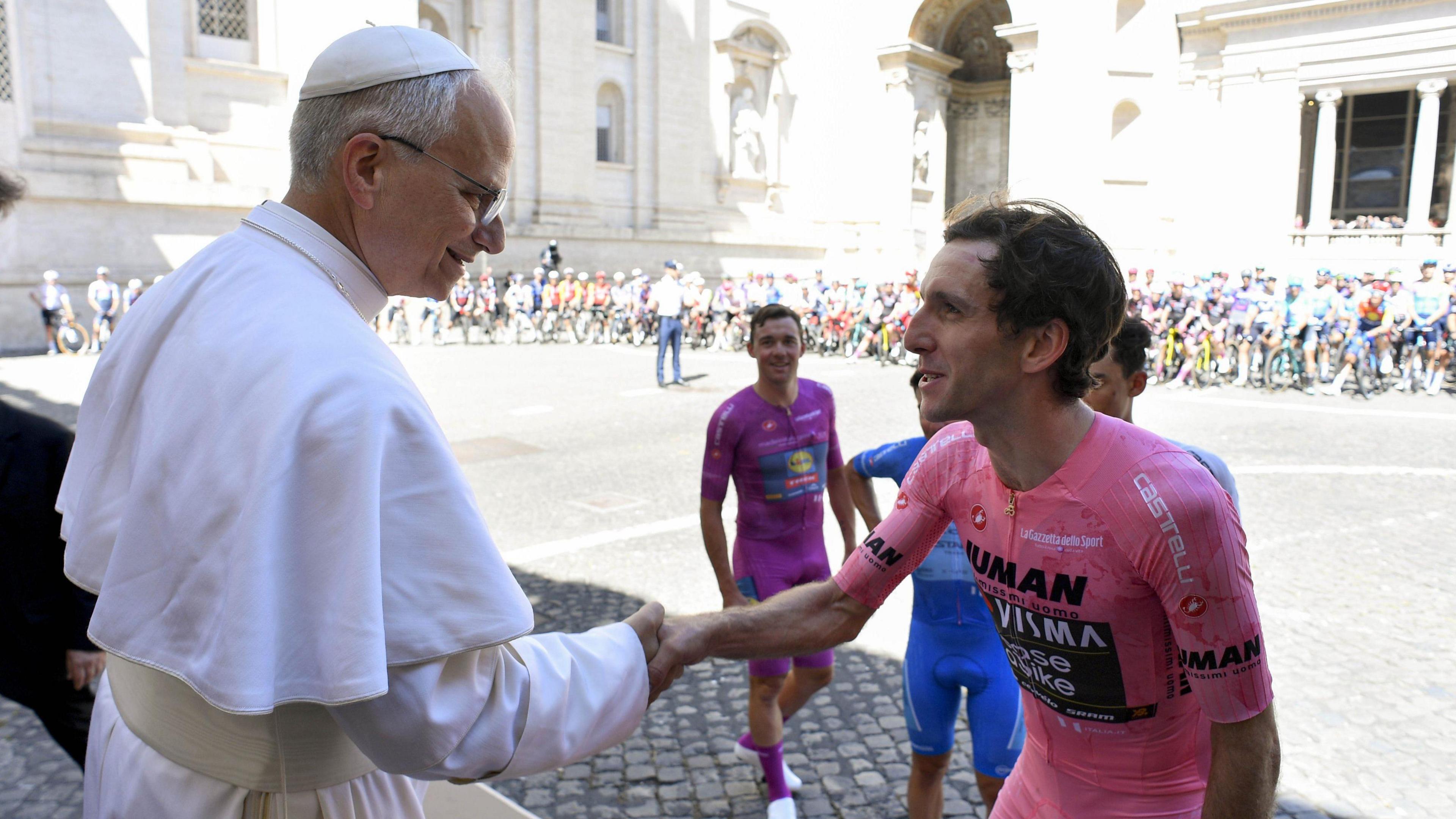 Pope Leo XIV (left) and British cyclist Simon Yates (right) shake hands in the Vatican