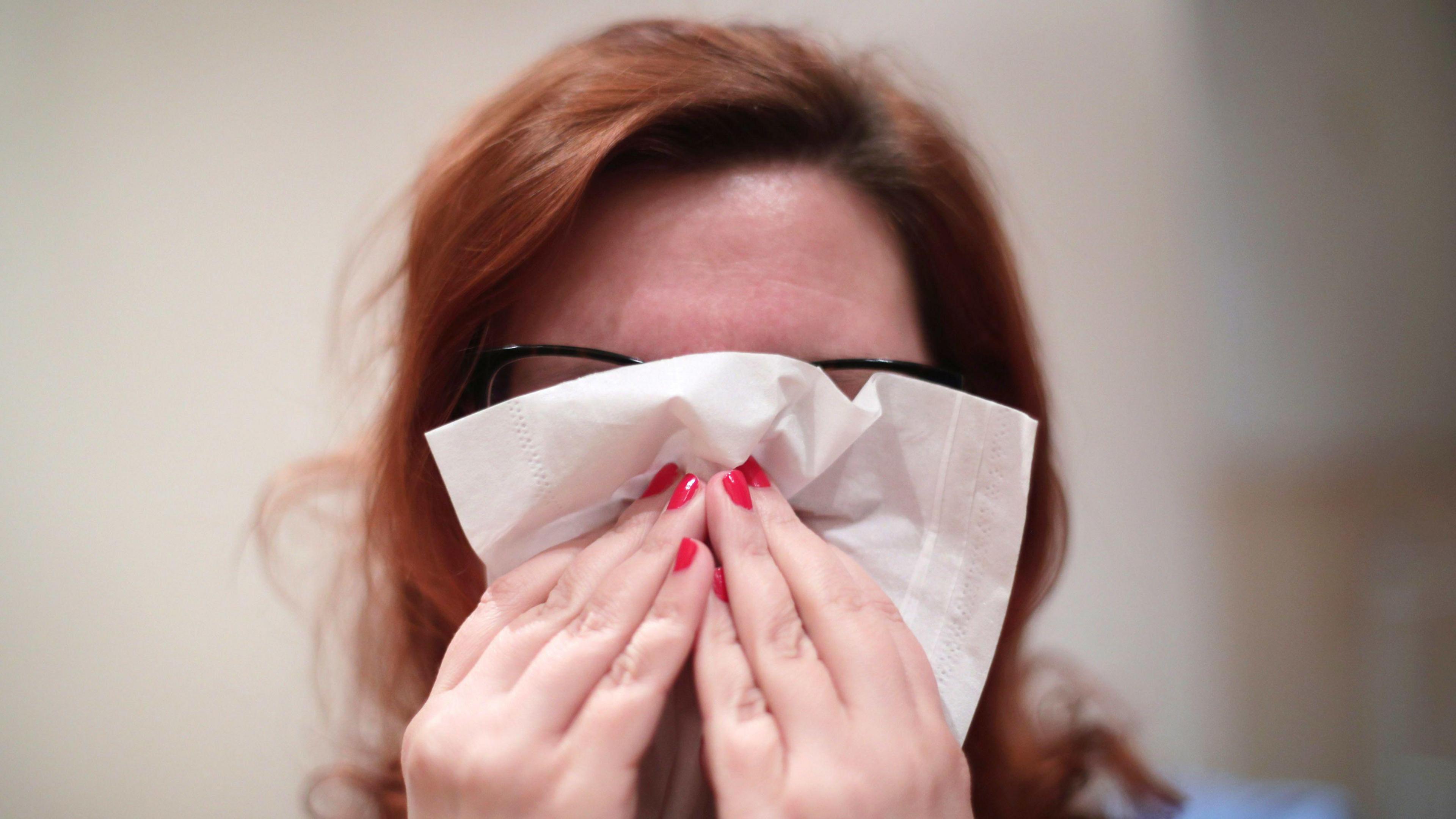 A woman blowing her nose