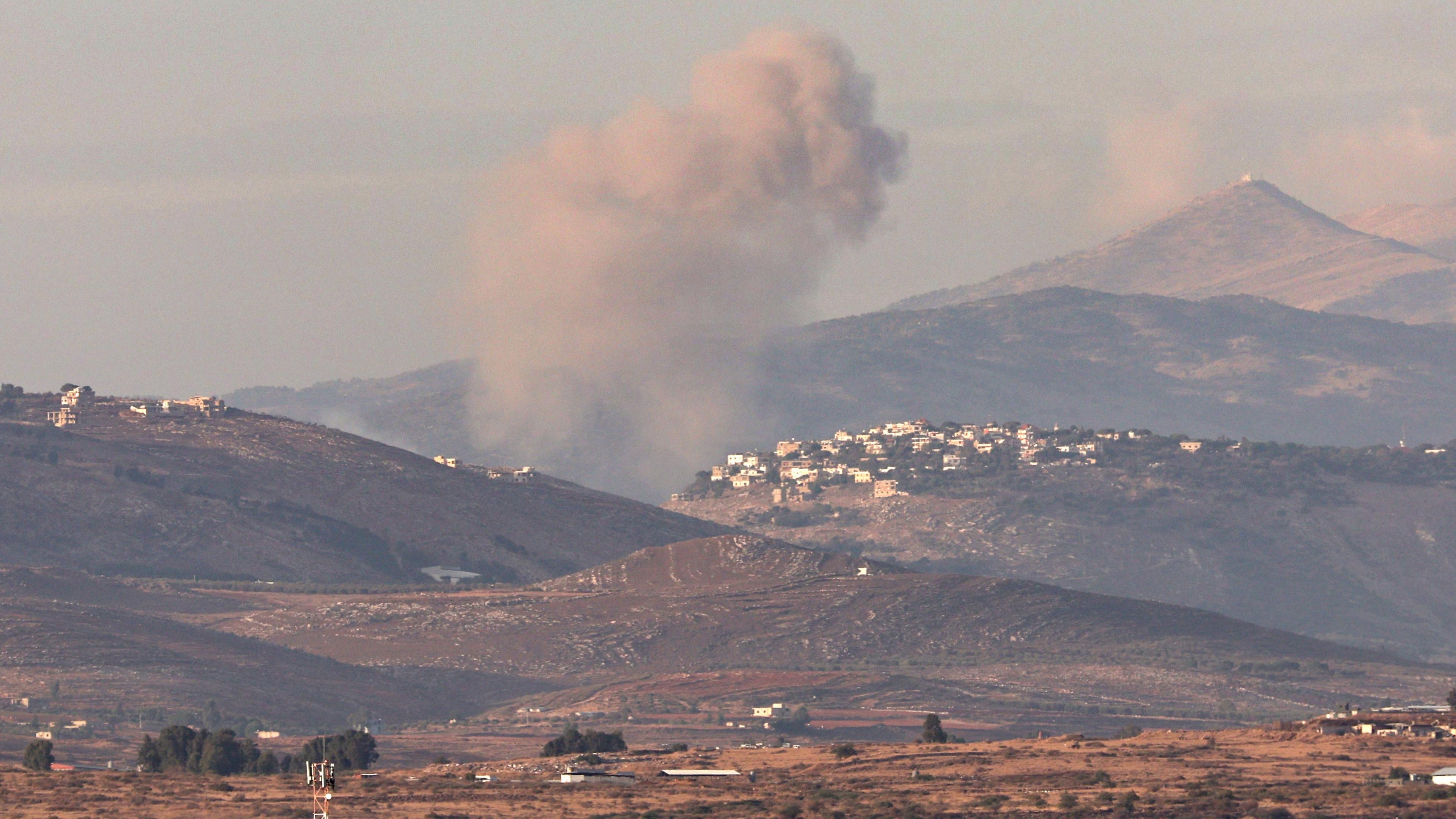 Smoke rises following an Israeli strike on the border village of Khiam in southern Lebanon, as seen from northern Israel (17 November 2024)