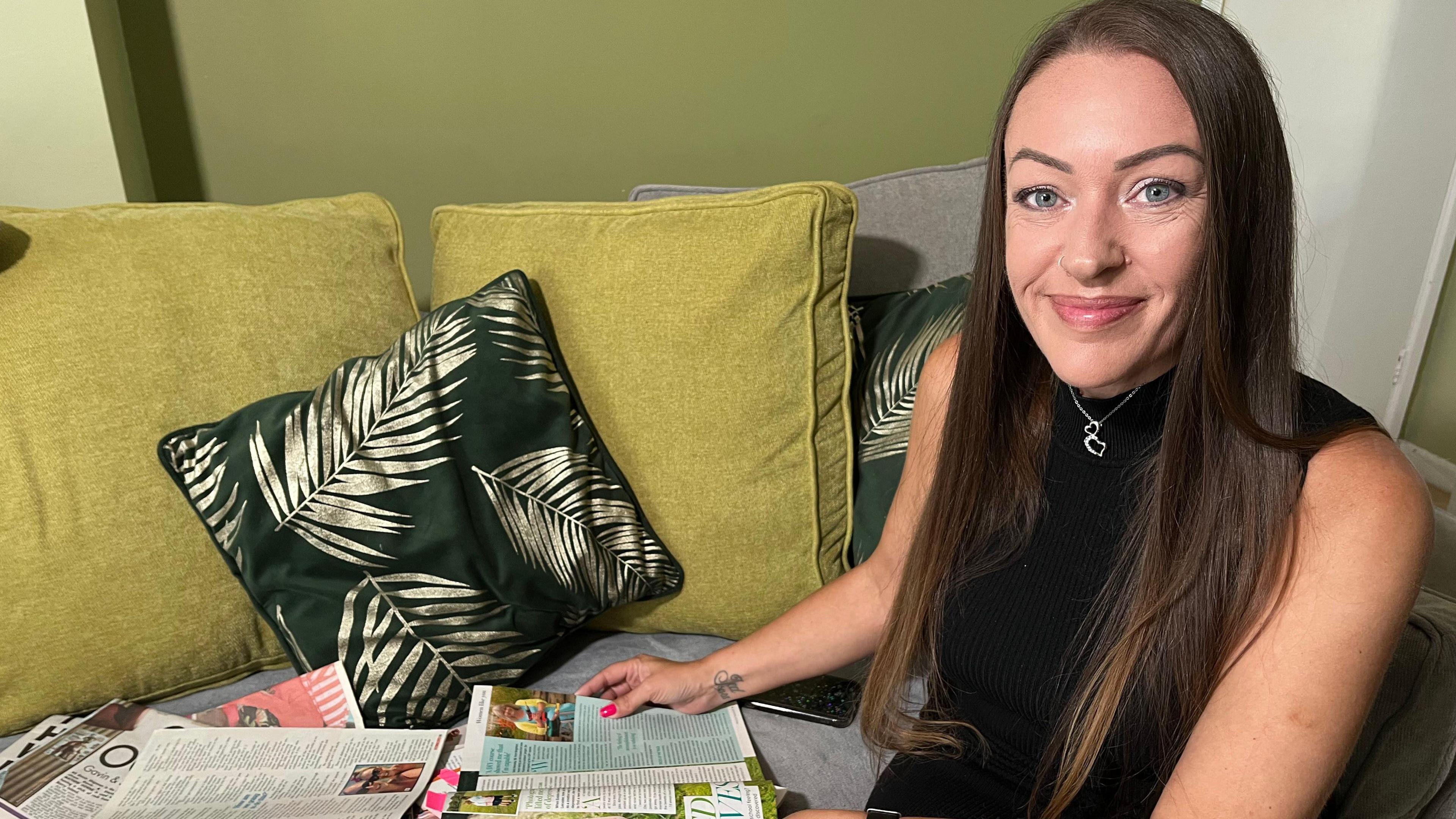 Estelle looks through newspaper and magazine cuttings featuring her social marketing clients