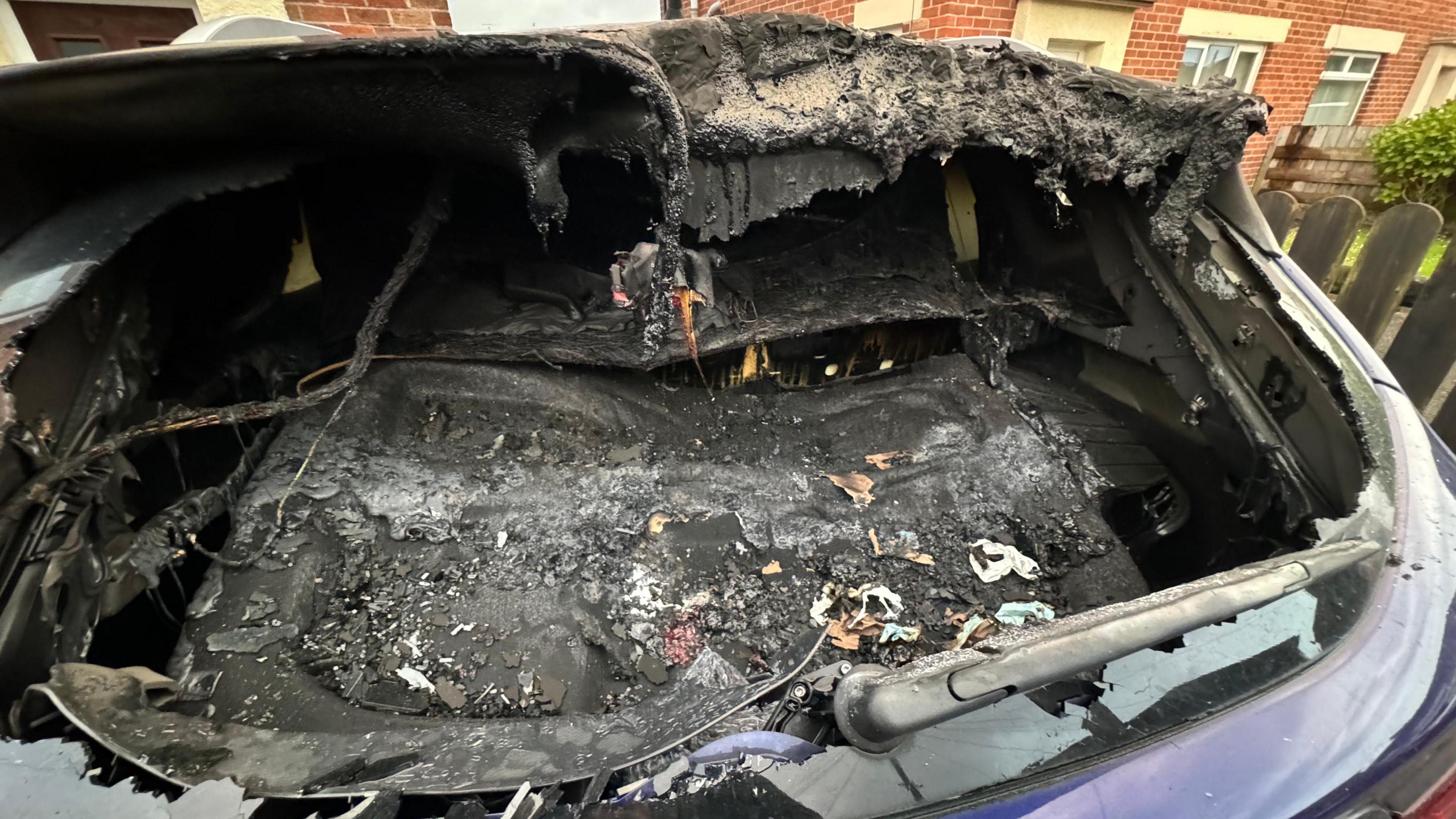 The rear of a vehicle significantly damaged as a result of a petrol bomb attack in the Espey Park area of Killyman.