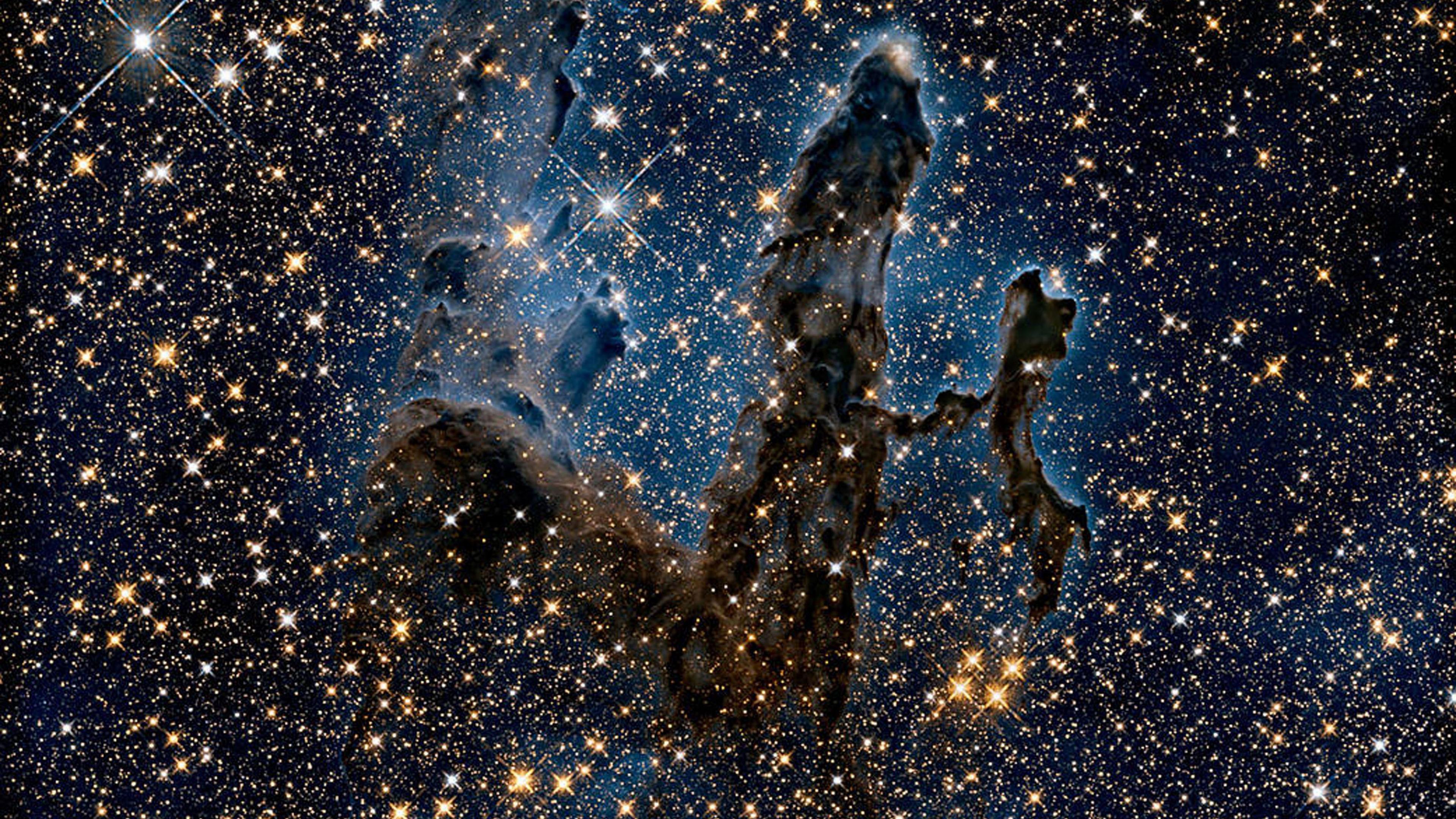 A dark blue sky littered with stars of white and yellow. A black smudge-looking blob sits in the middle.