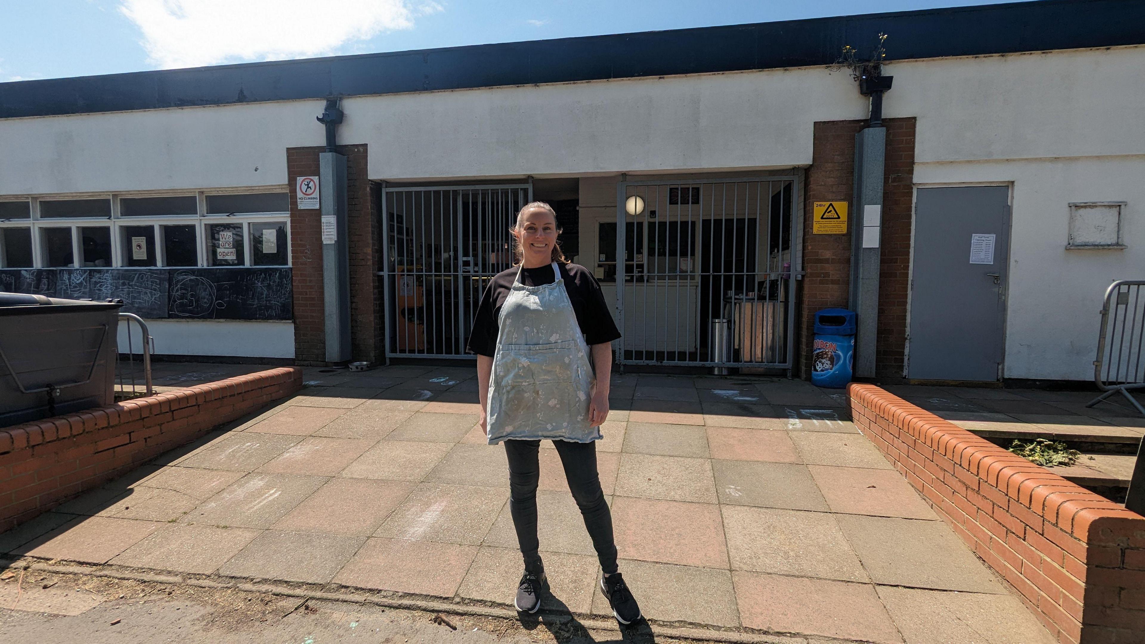 Woman in apron outside building