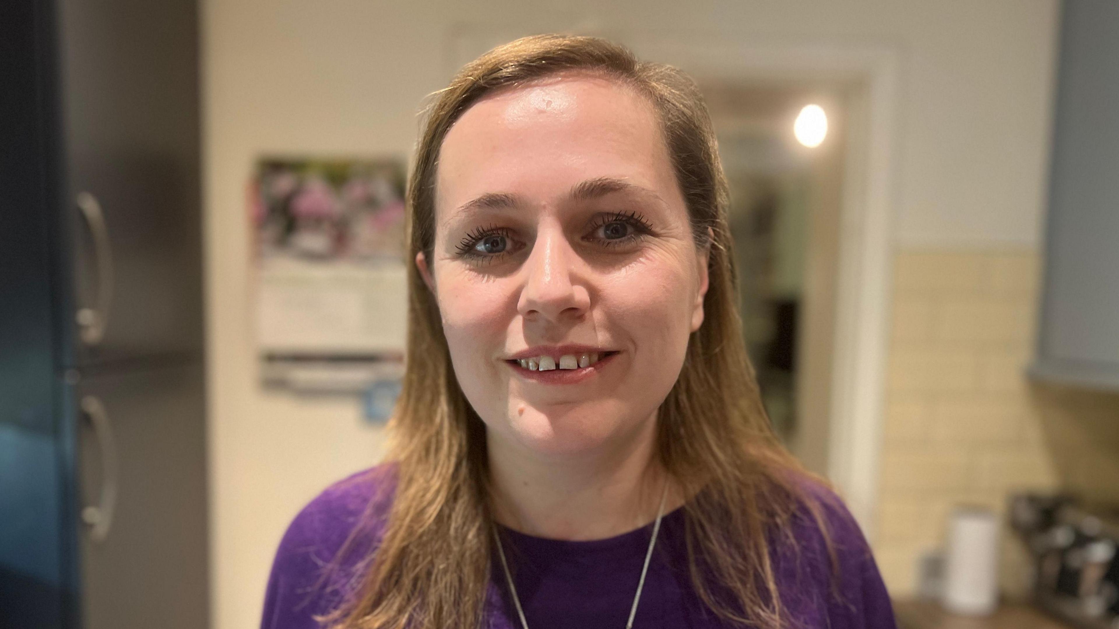 Jen Craft MP looking at the camera smiling in a kitchen.