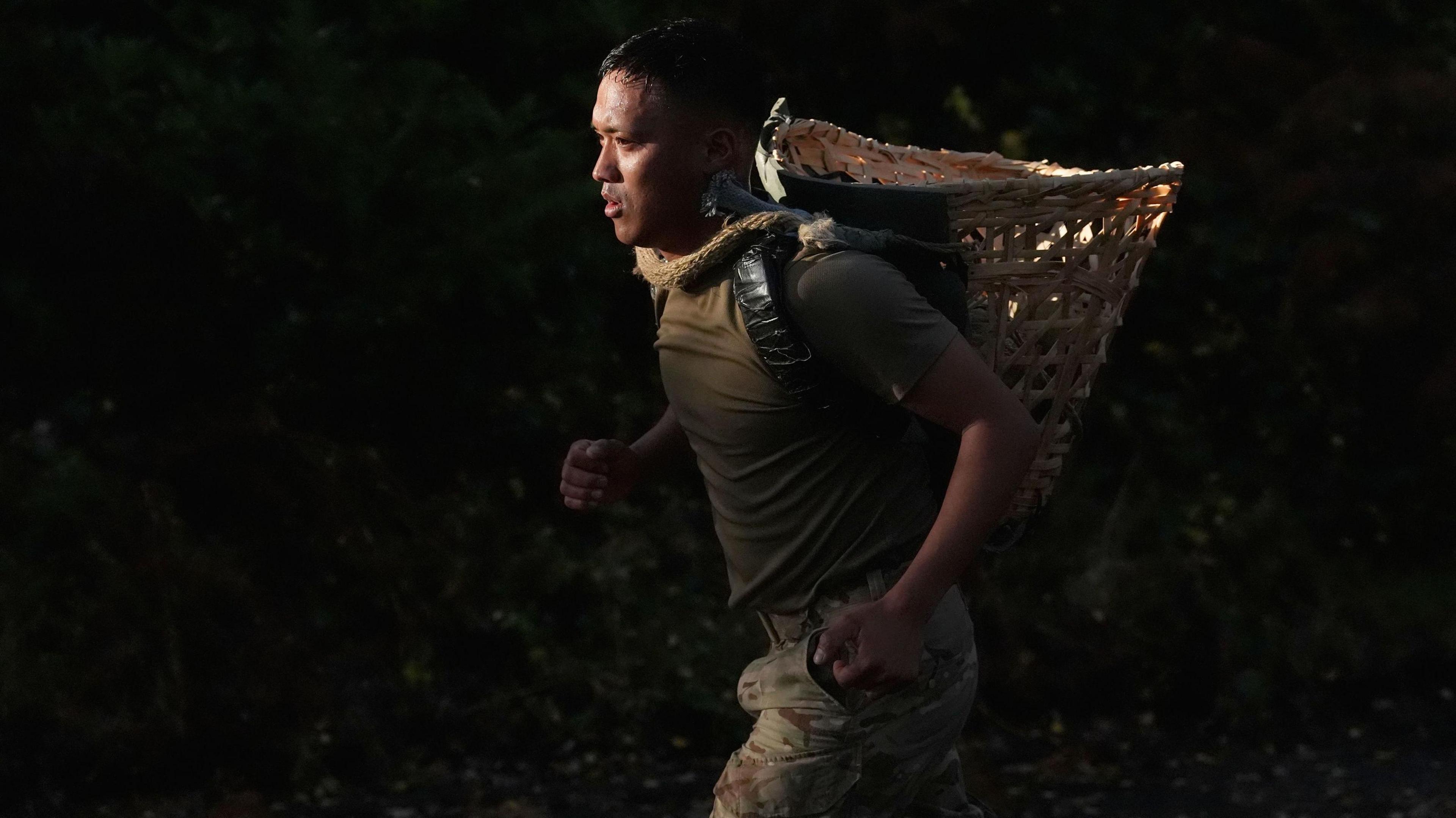 One member of the military taking part in the tri-service Gurkha Doko race, carrying a Doko, a traditional Nepalese bamboo basket, weighing 15kg over five kilometres, at the Army Training Centre in Pirbright, Surrey.