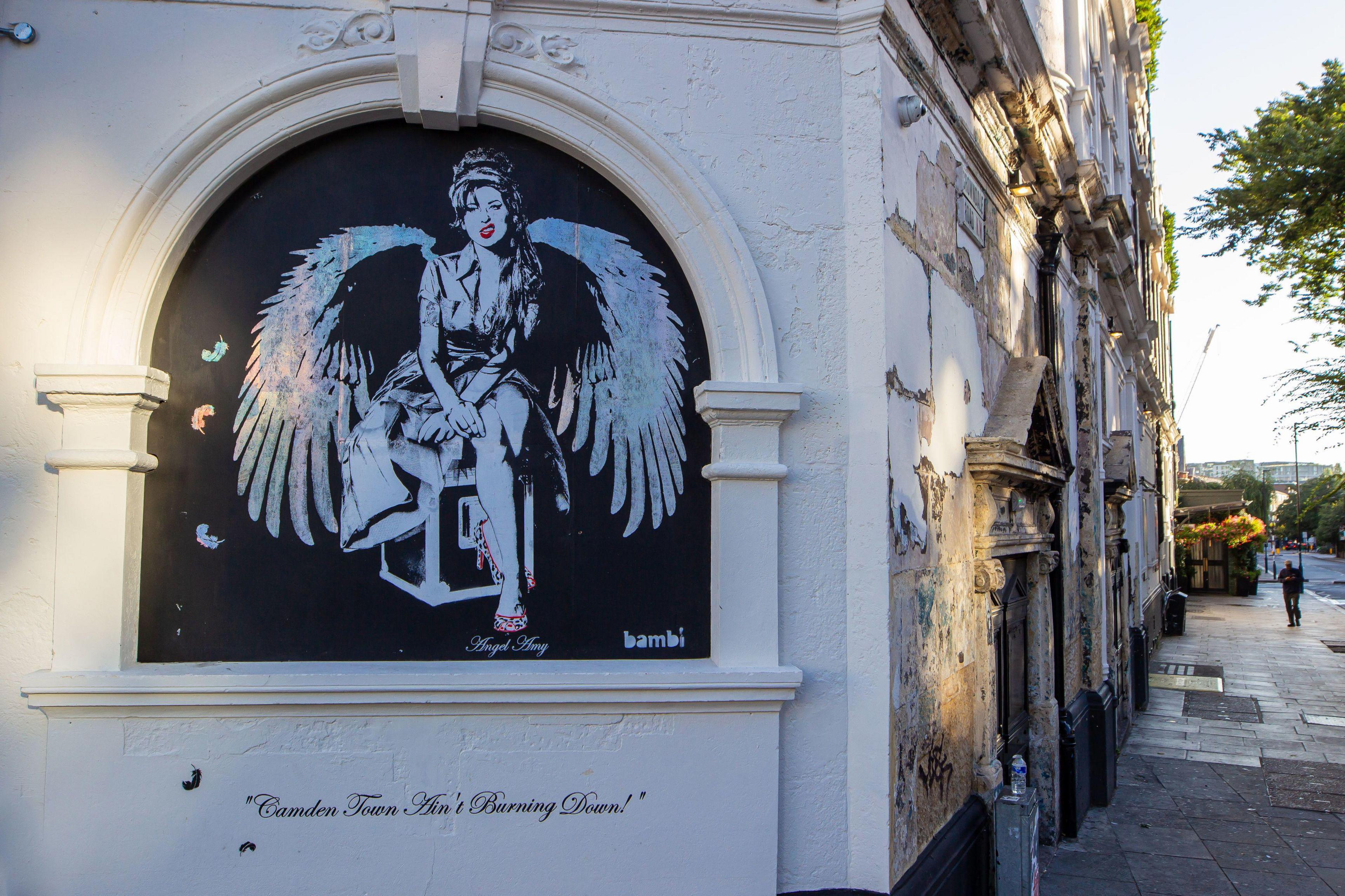 Black and white painting of Amy Winehouse with angel wings on the wall of Koko