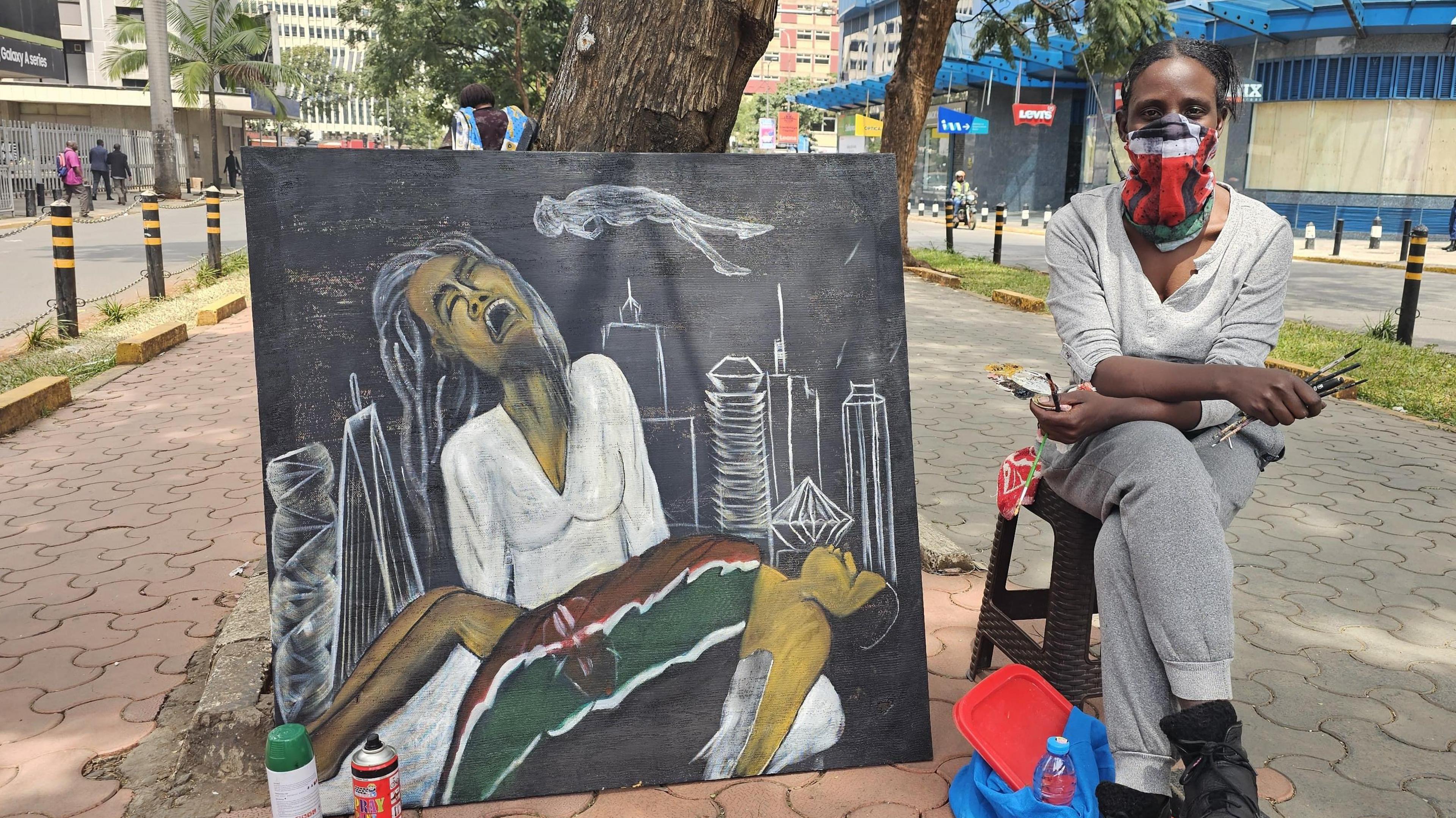 An artist with her artwork depicting a protester who was shot dead by police