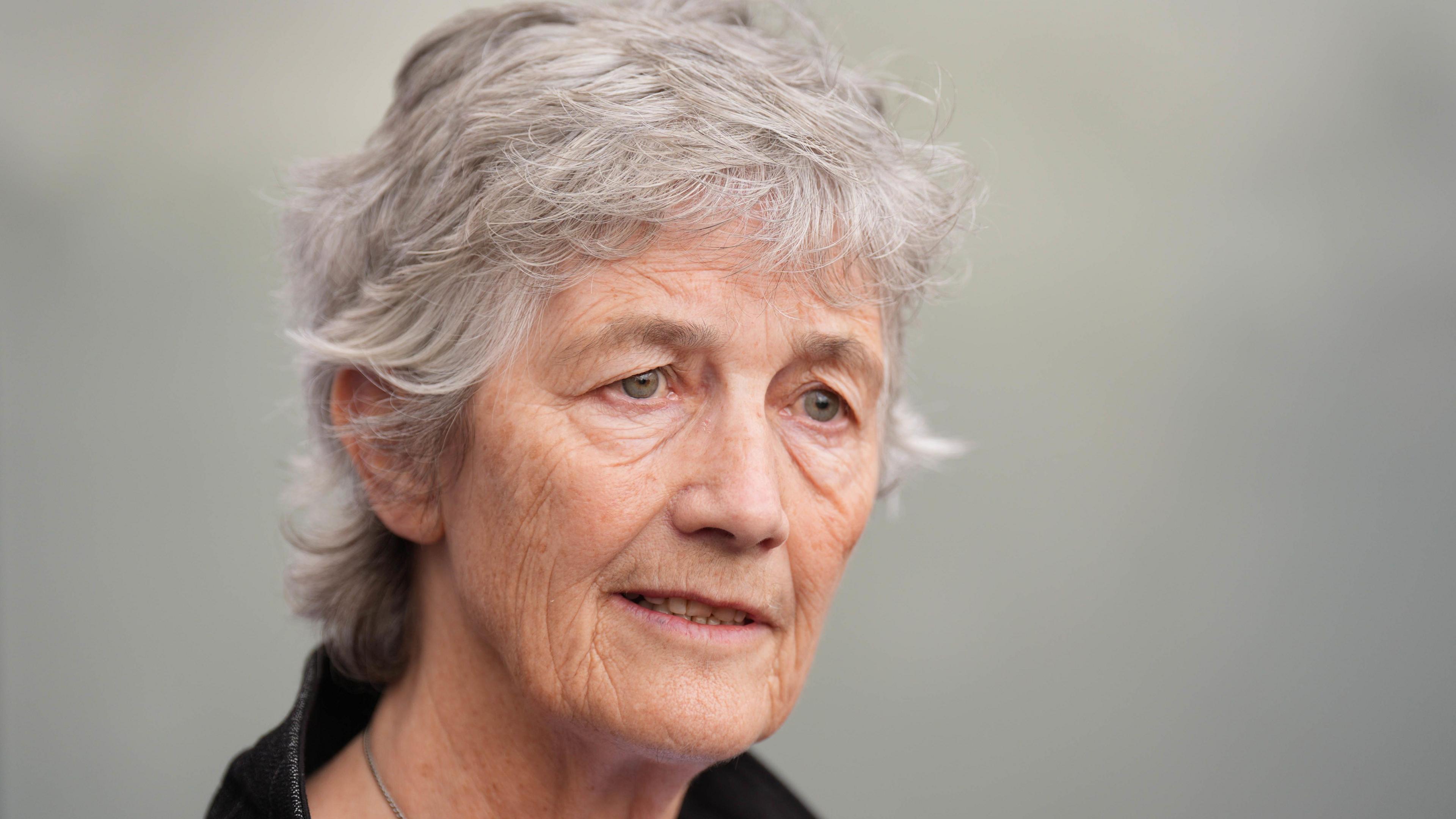 A close-up image of Catherine Connolly. She is an older woman, with short grey hair. The background is blurred. She has her mouth slightly open.