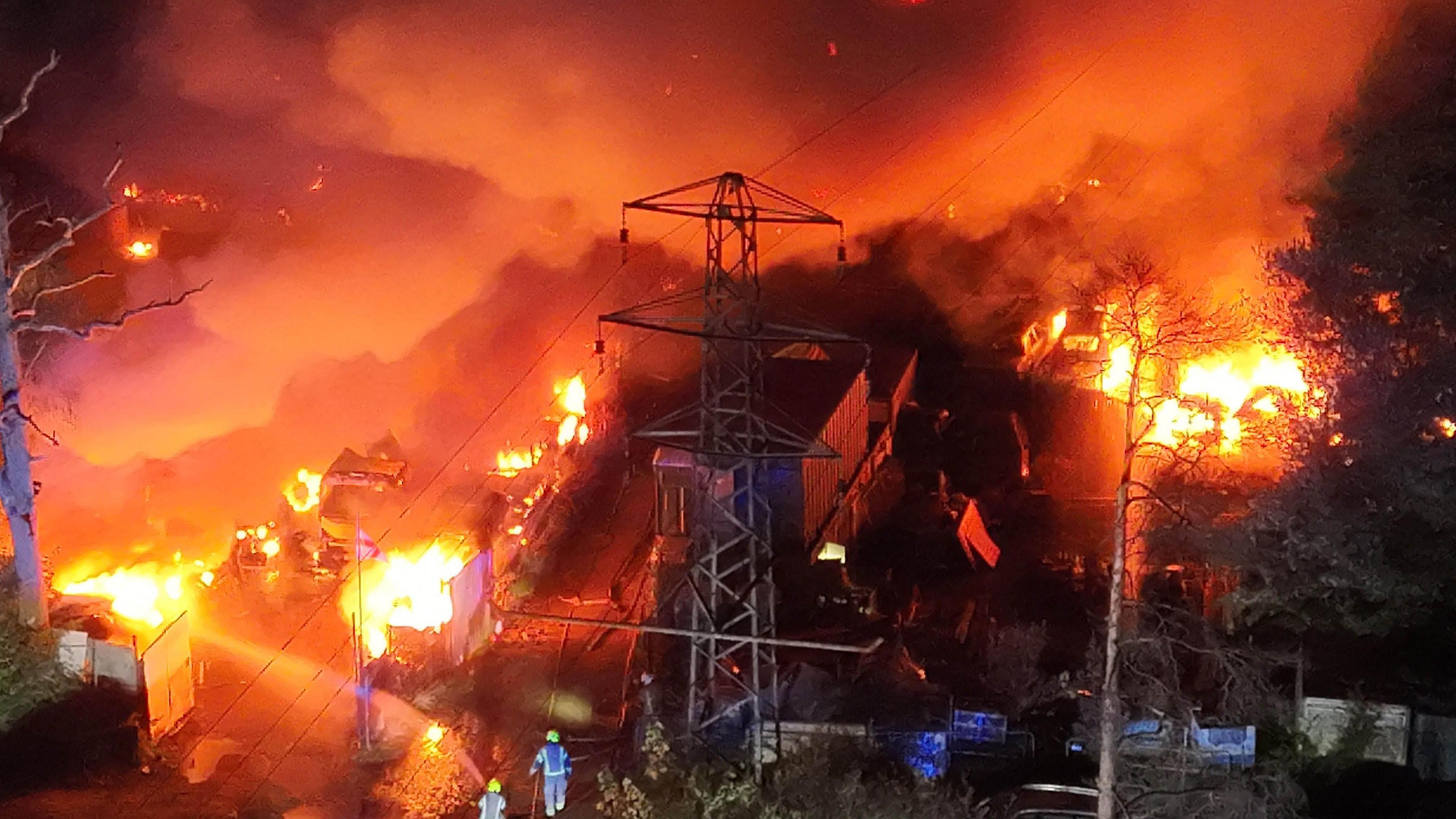 An aerial view of a fire destroying cars and other property at a business park. 