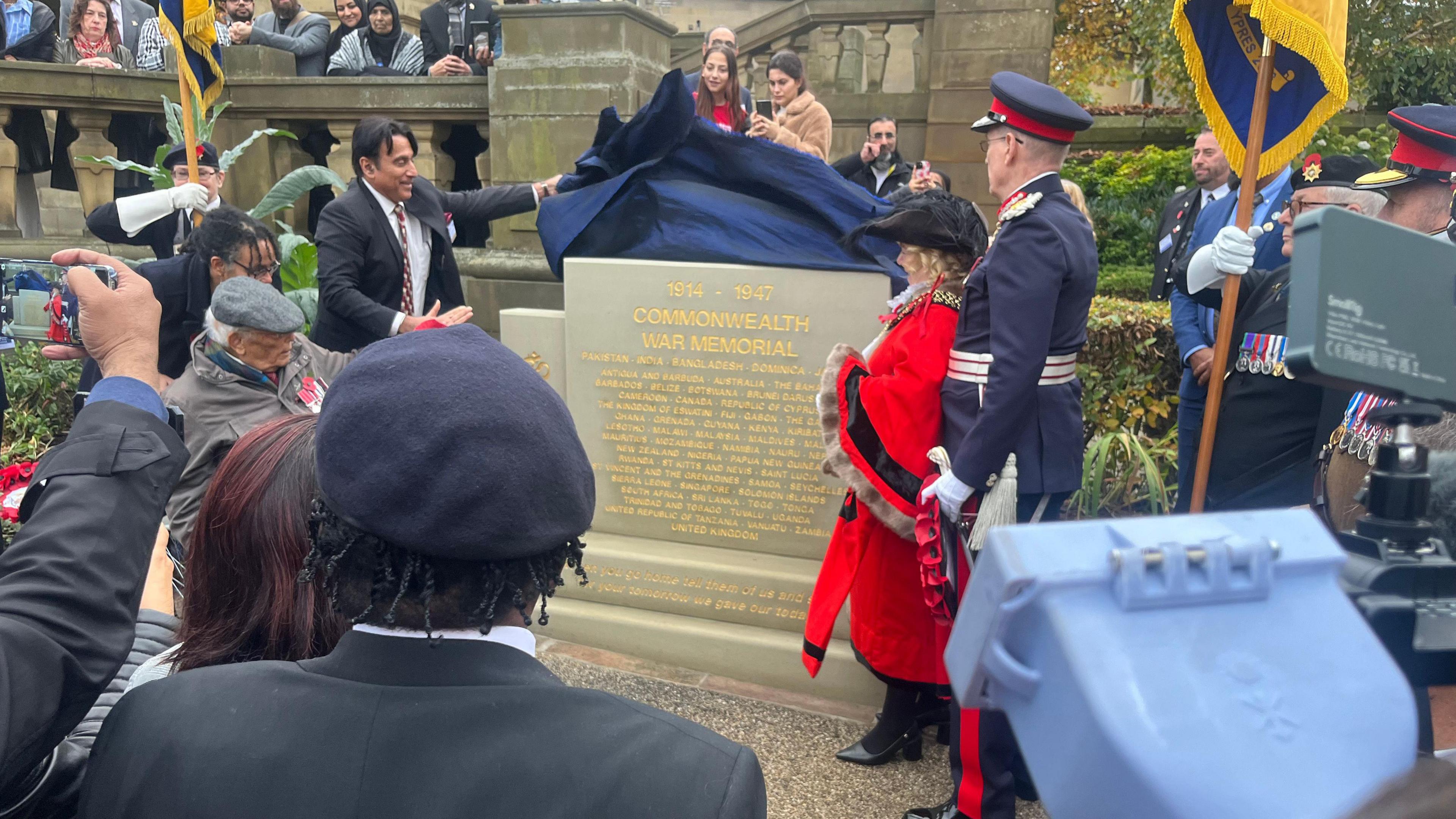 People watching a war memorial being unveiled