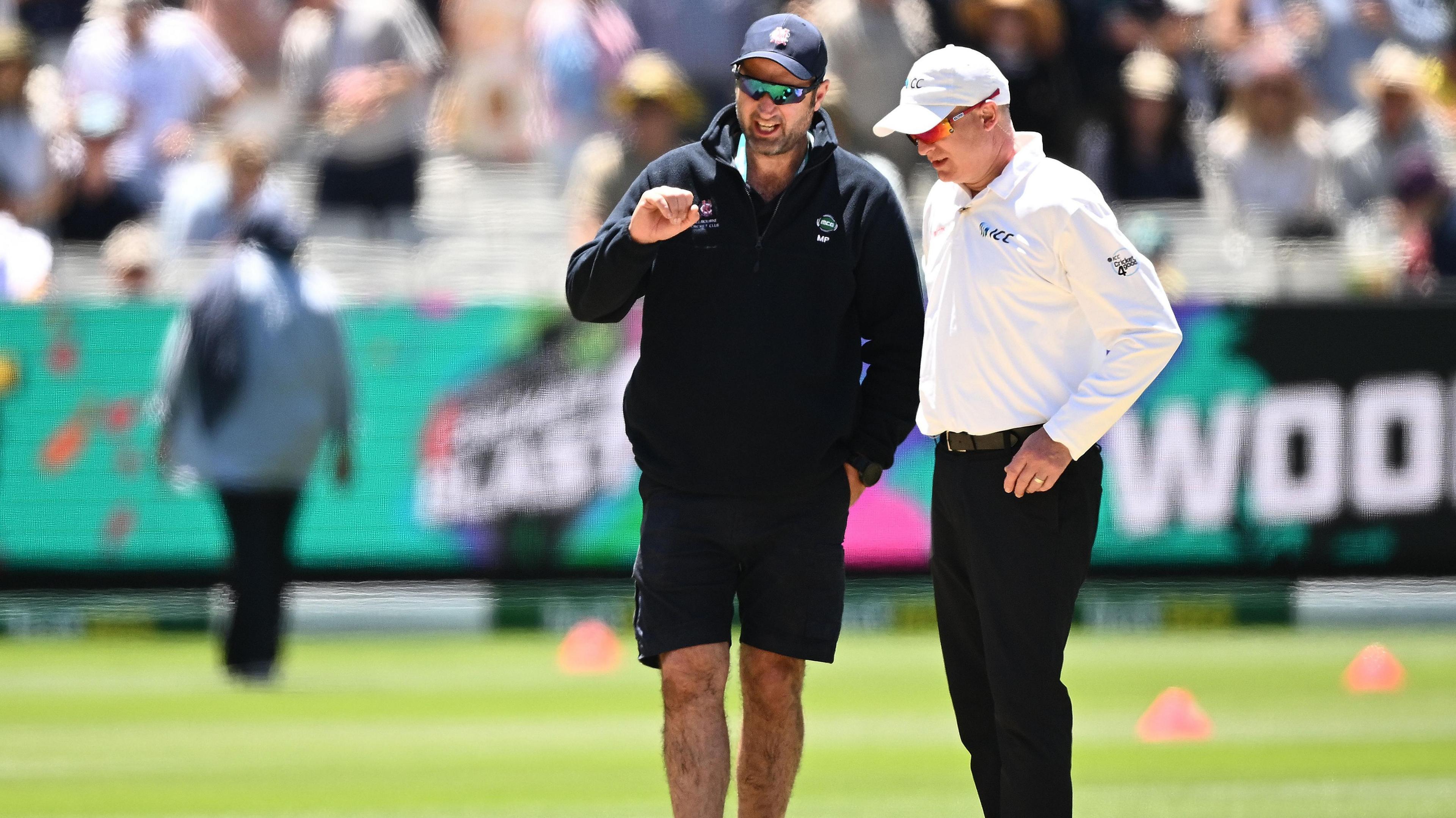 Melbourne Cricket Ground head curator Matt Page (left) inspects the pitch during the lunch break on day two of the fourth Ashes Test