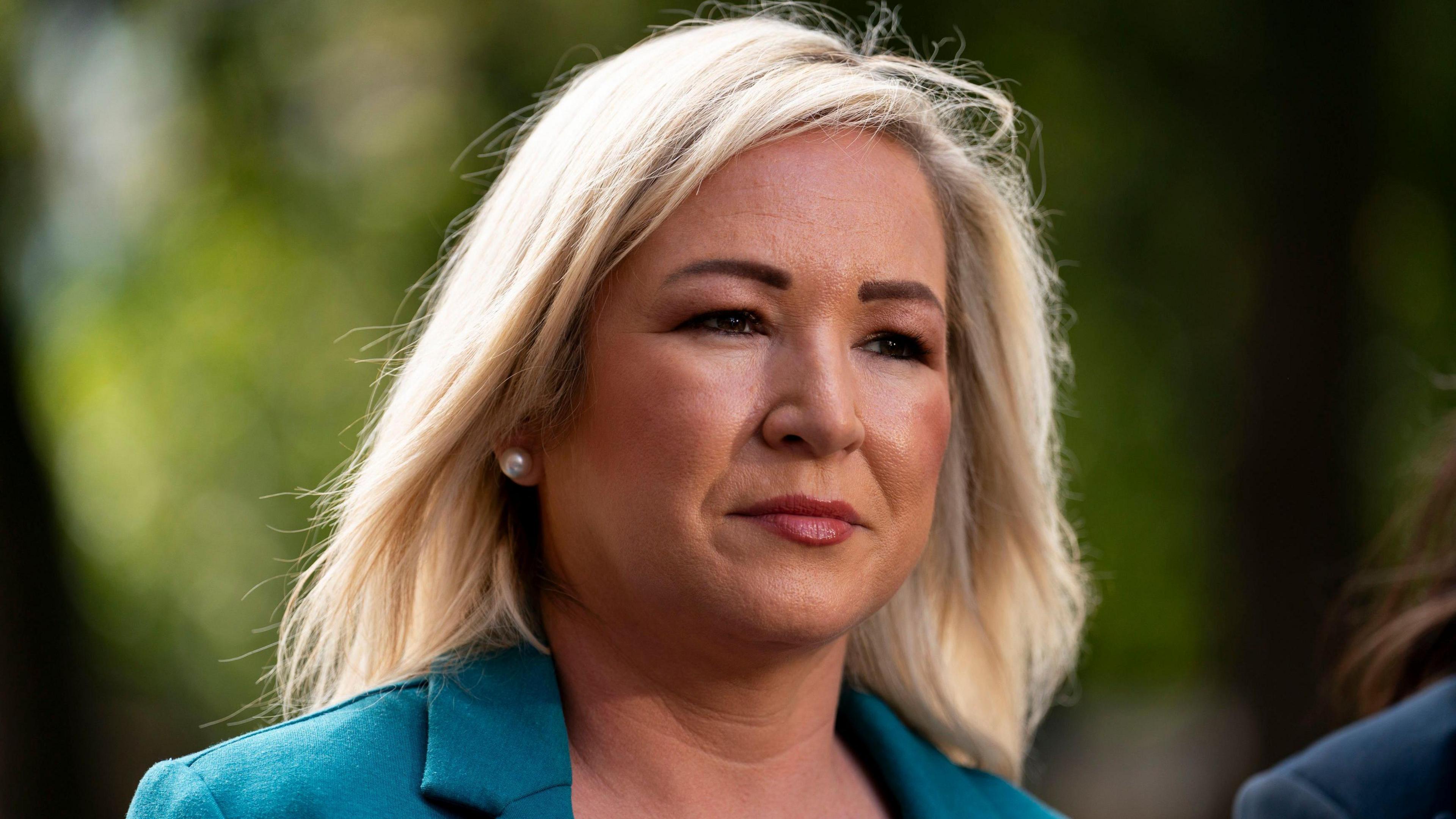 Michelle O'Neill - a woman outside with blond hair wearing a blue jacket. 