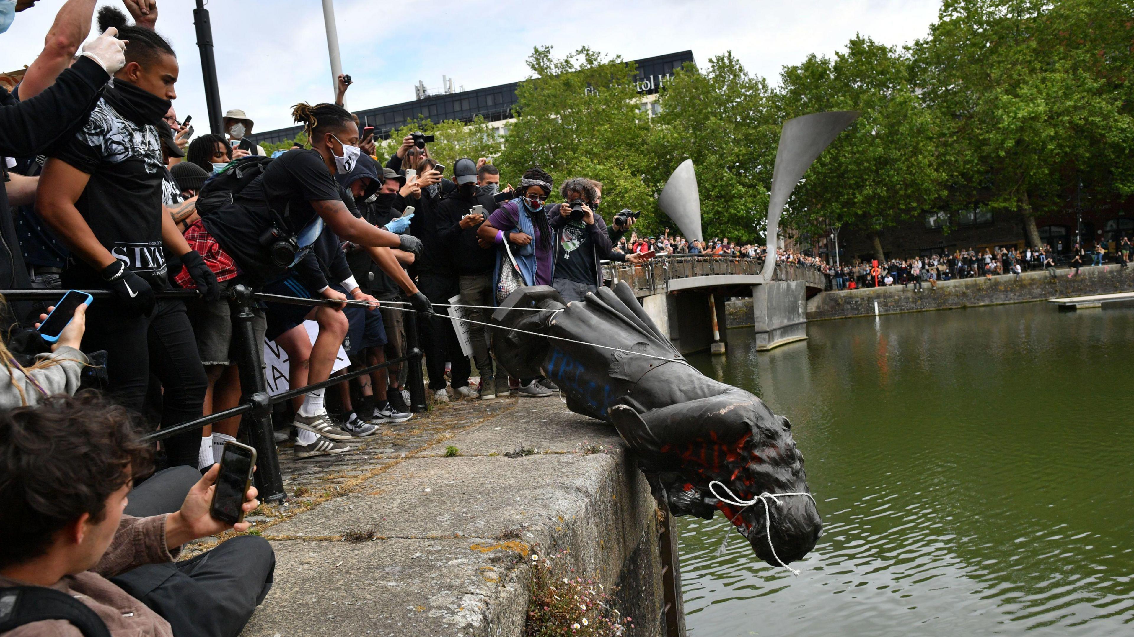 The Edward Colston statue being toppled into the Bristol harbour by protestors in 2020