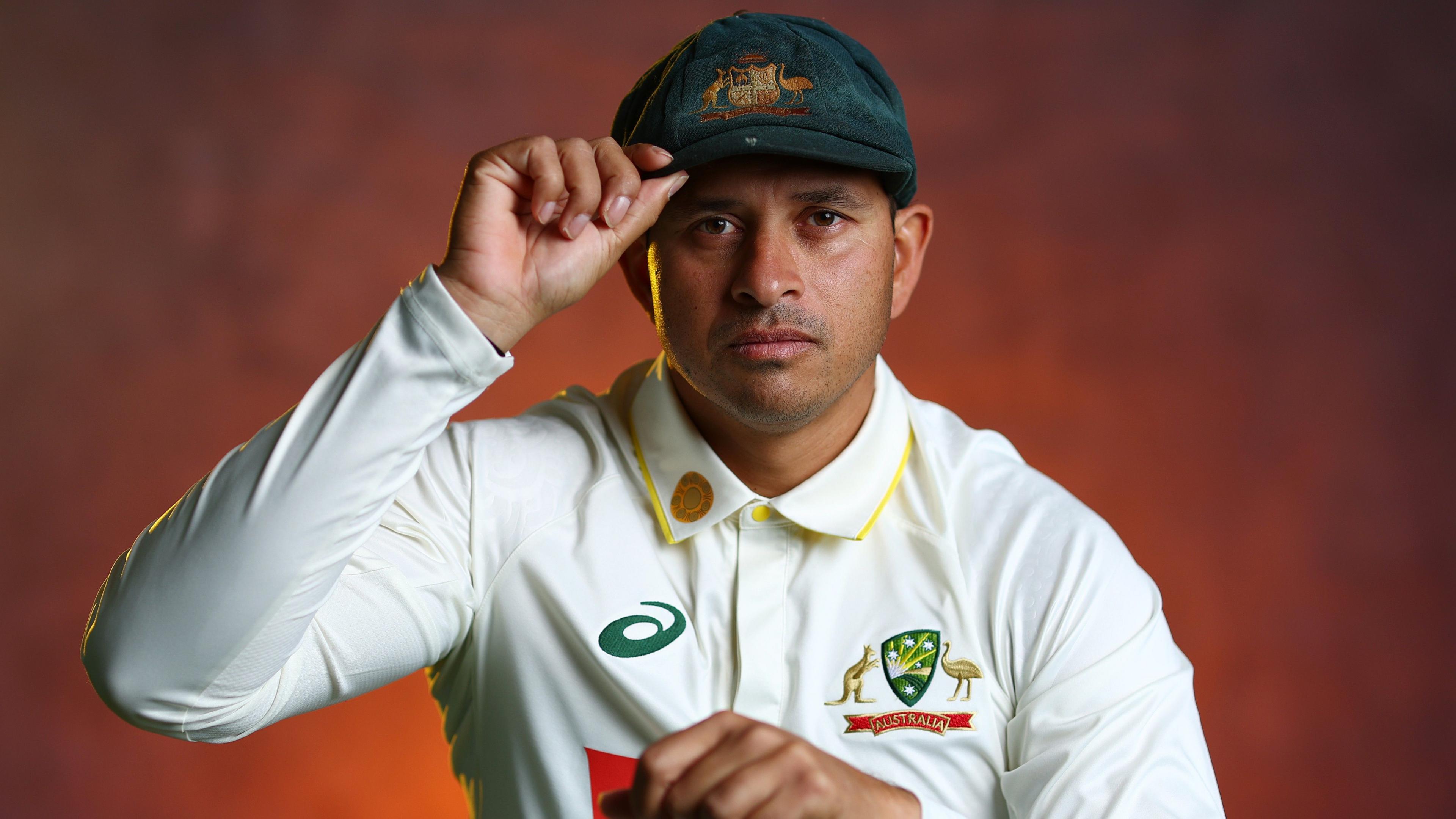 Usman Khawaja looks at the camera while holding his Baggy Green