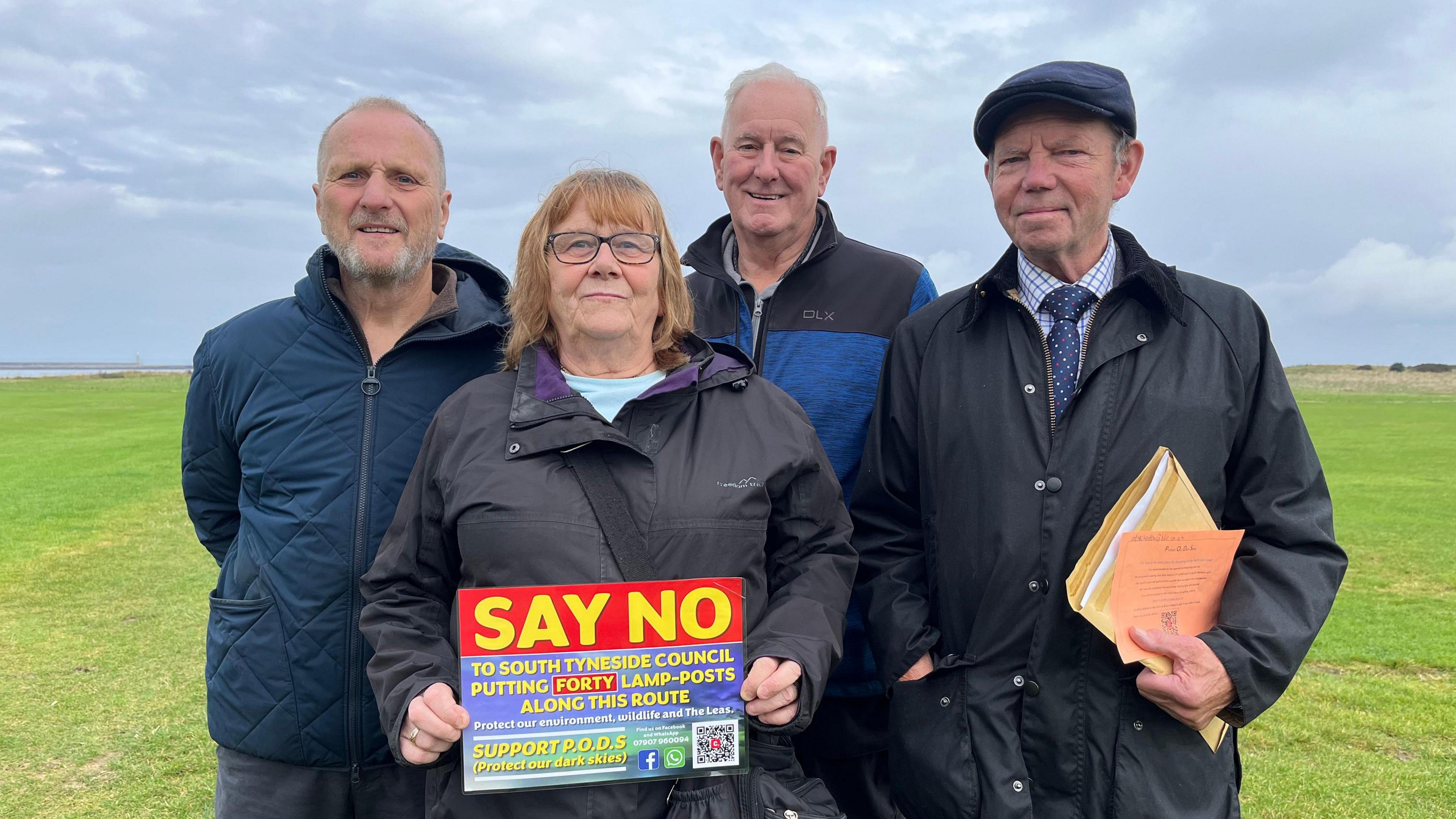 Campaigners stand on the Leas, holding up a sign which asks people to support their petition