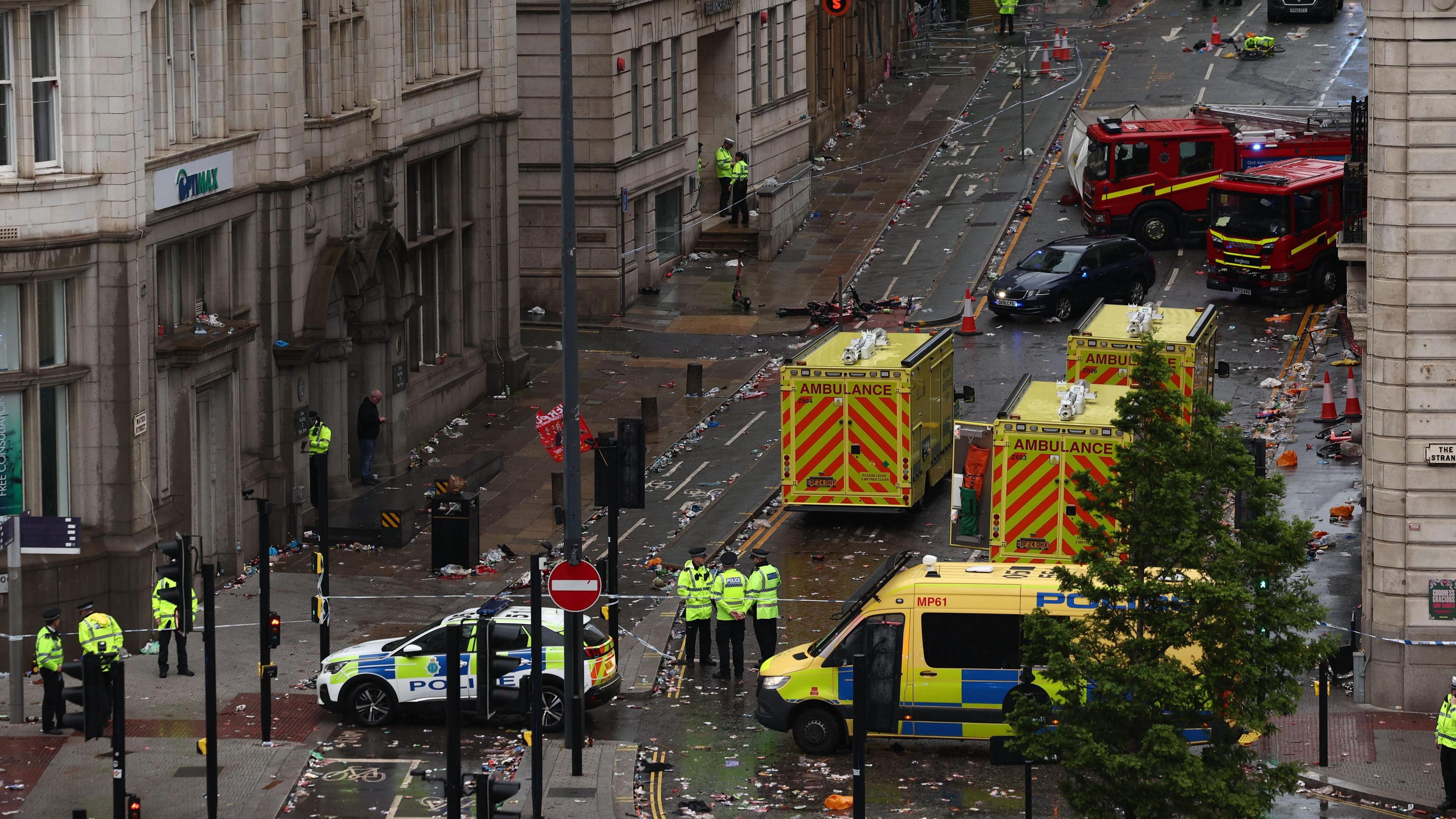 Ambulances and fire engine line a street in Liverpool.