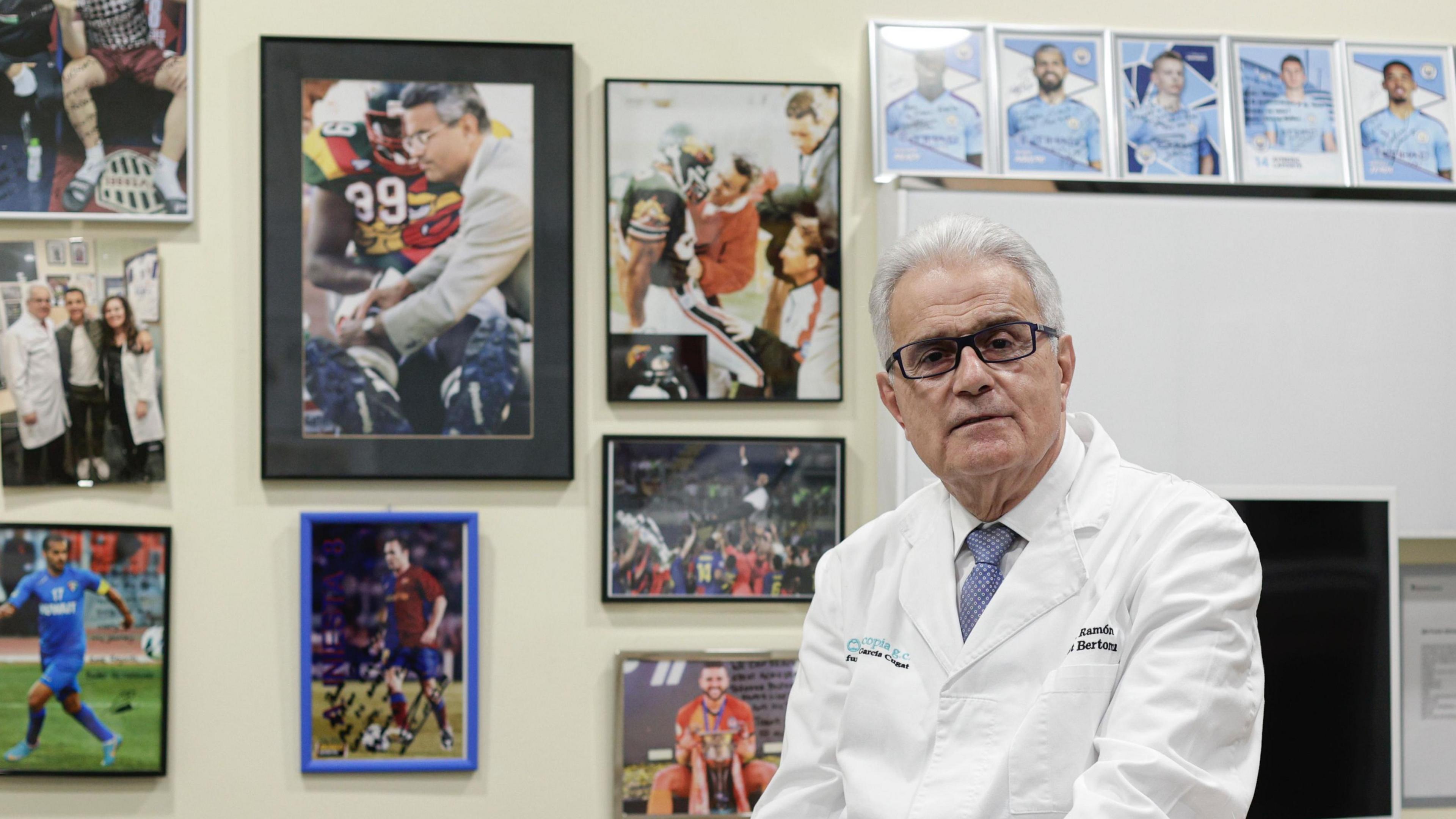 Dr Ramon Cugat in his office, the walls adorned with pictures of footballers.