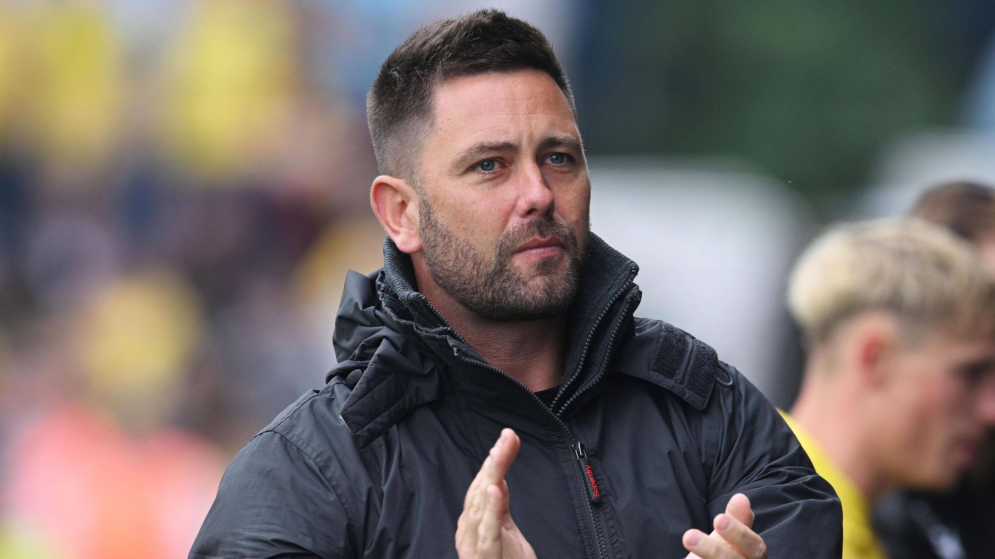 Oxford head coach Des Buckingham claps the fans during a Championship game against Norwich City