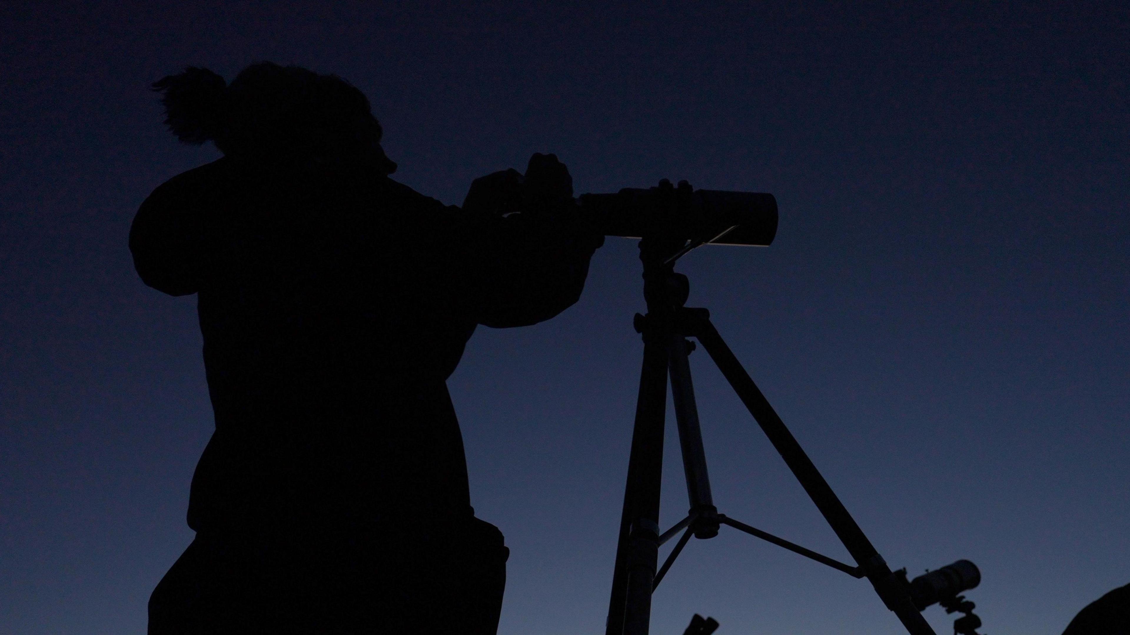 Jenifer Millard looking through a telescope 