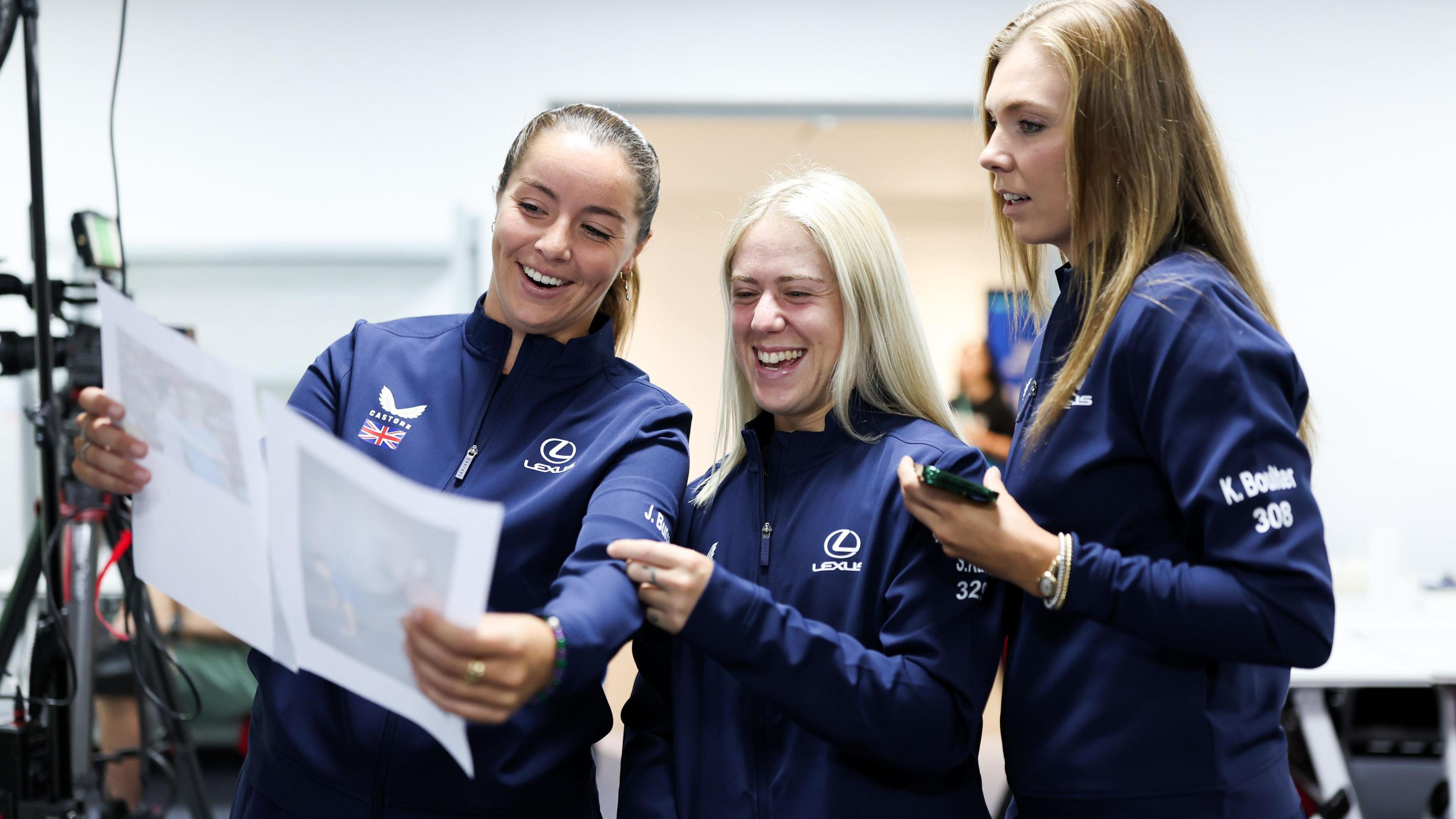 Jodie Burrage, Sonay Kartal and Katie Boulter look at a picture 