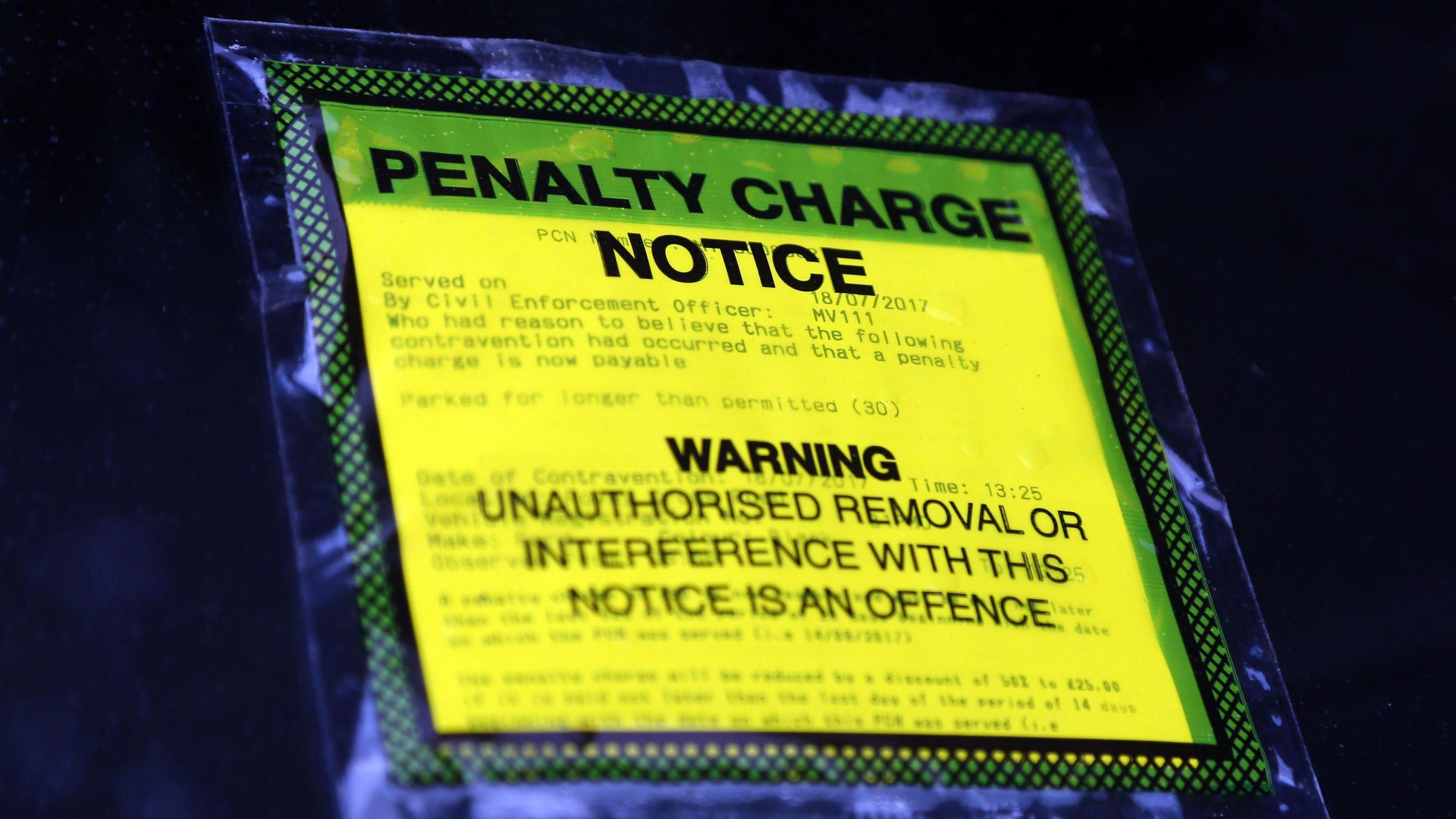 A penalty charge notice on the windscreen of a car