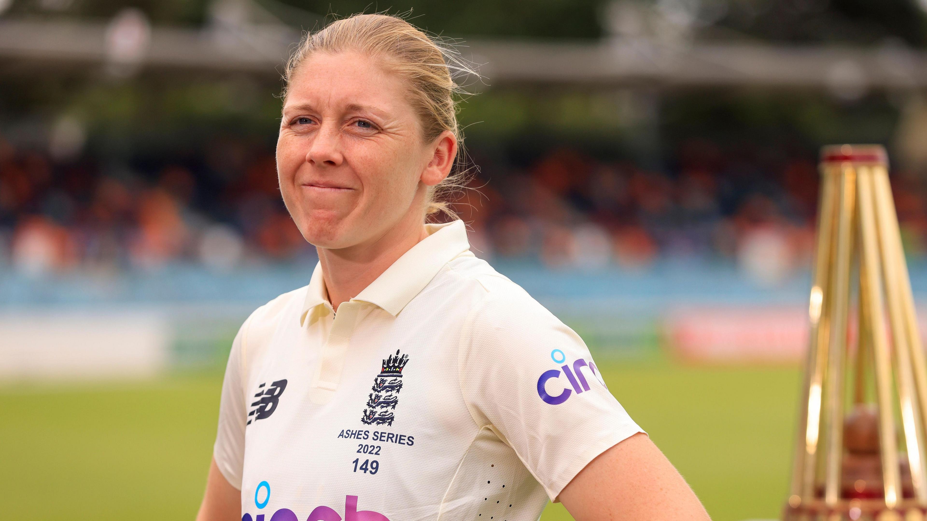 Heather Knight looks pained while stood by the Ashes trophy