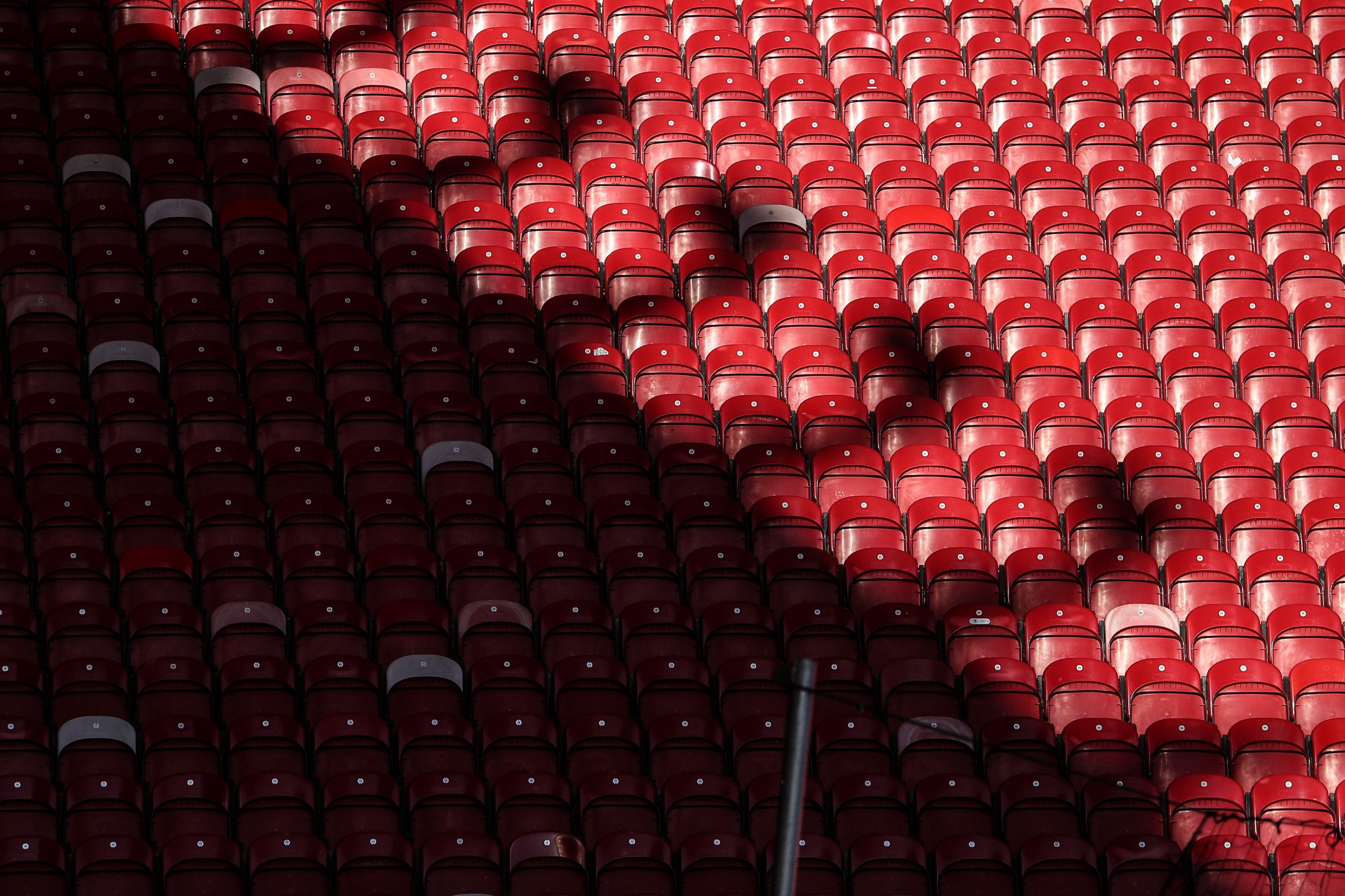 Rows of empty red seats at the Riverside stadium. The shadow of the roof of one of the stands covers half the seats diagonally top left to bottom right.