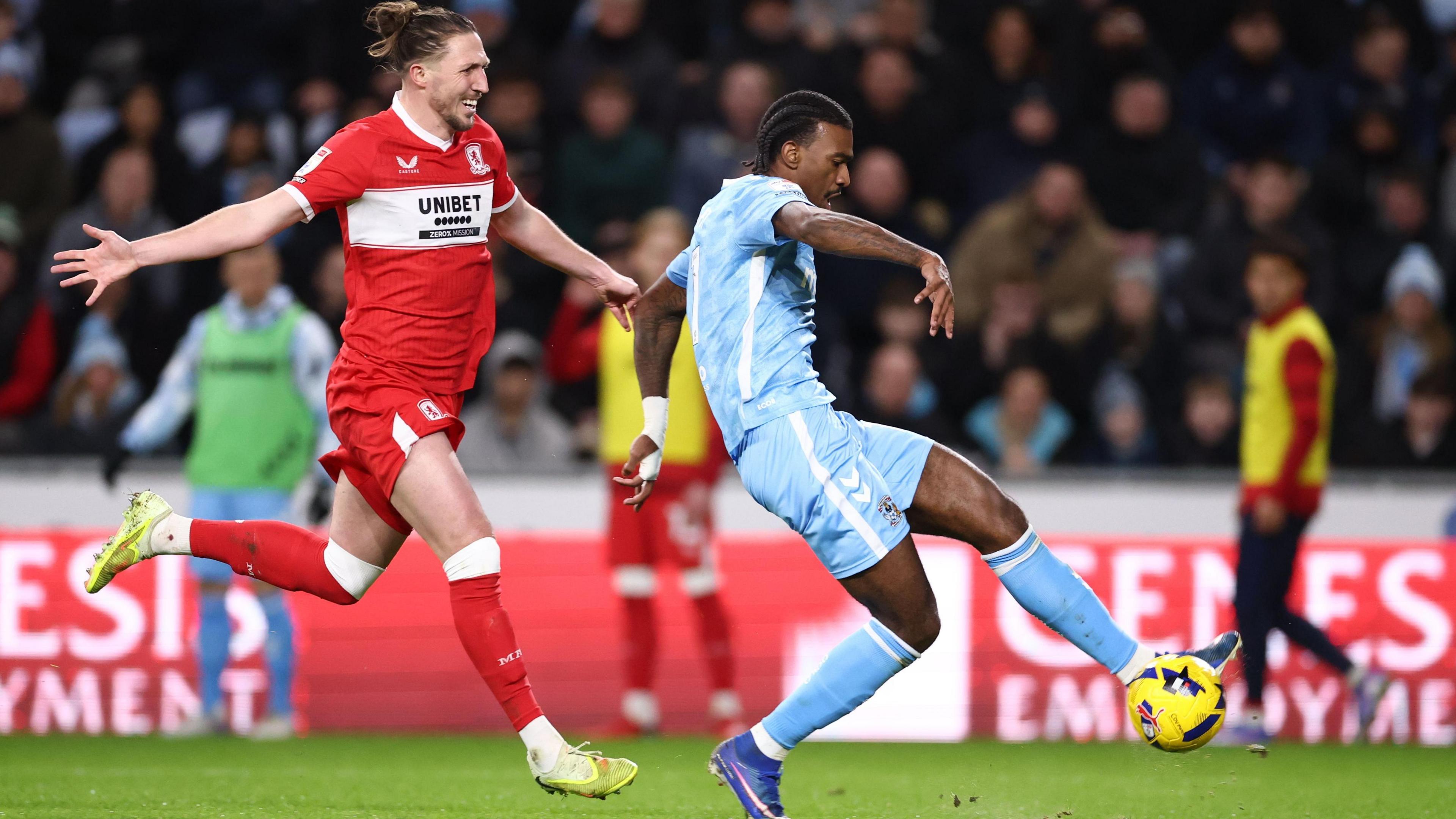 Luke Ayling (left) is trailing with his arms stretched out as Haji Wright is about to stroke home Coventry's second goal with his left foot