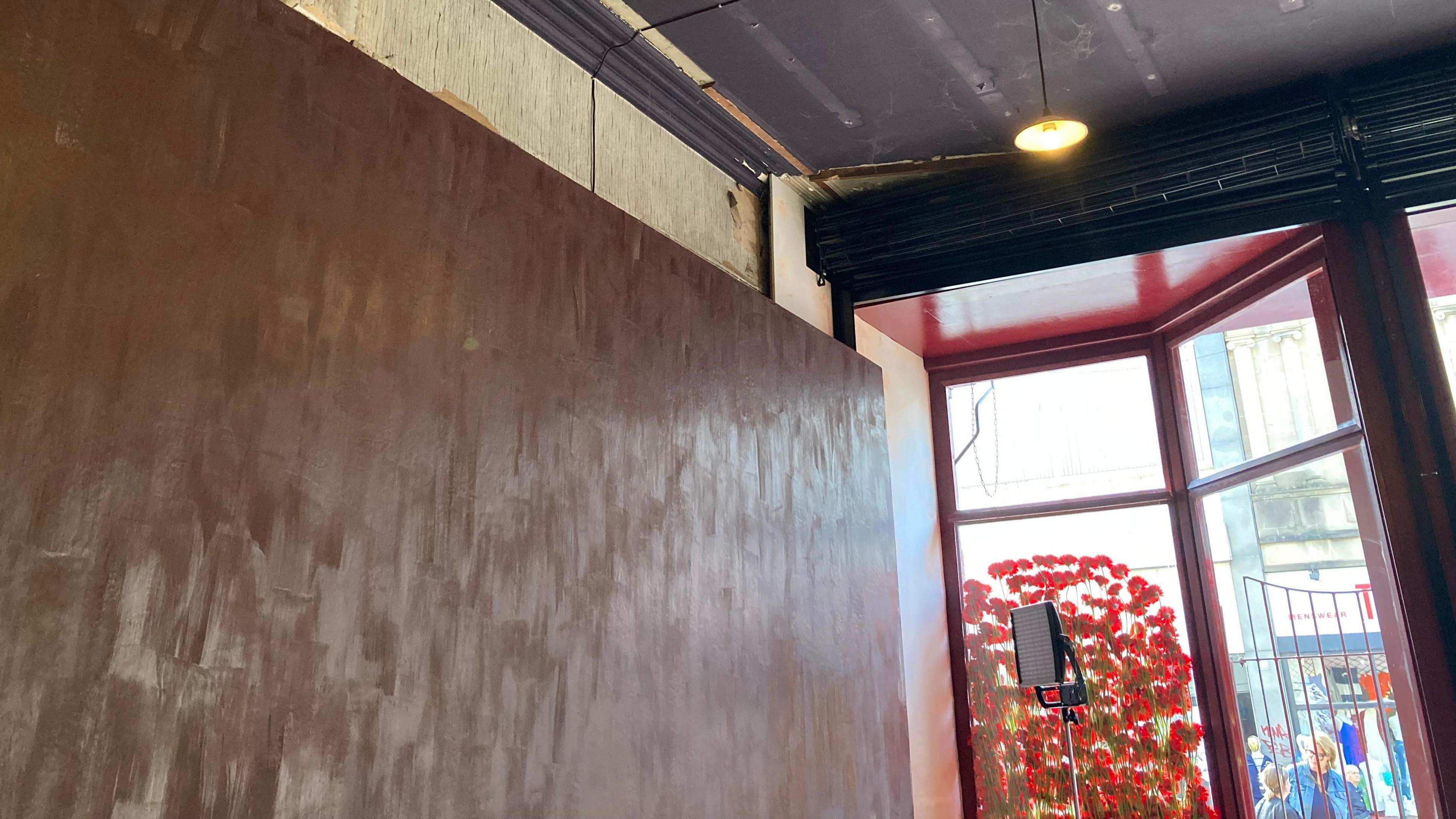 A wall painted with brown chocolate, next to a door looking out onto a high street