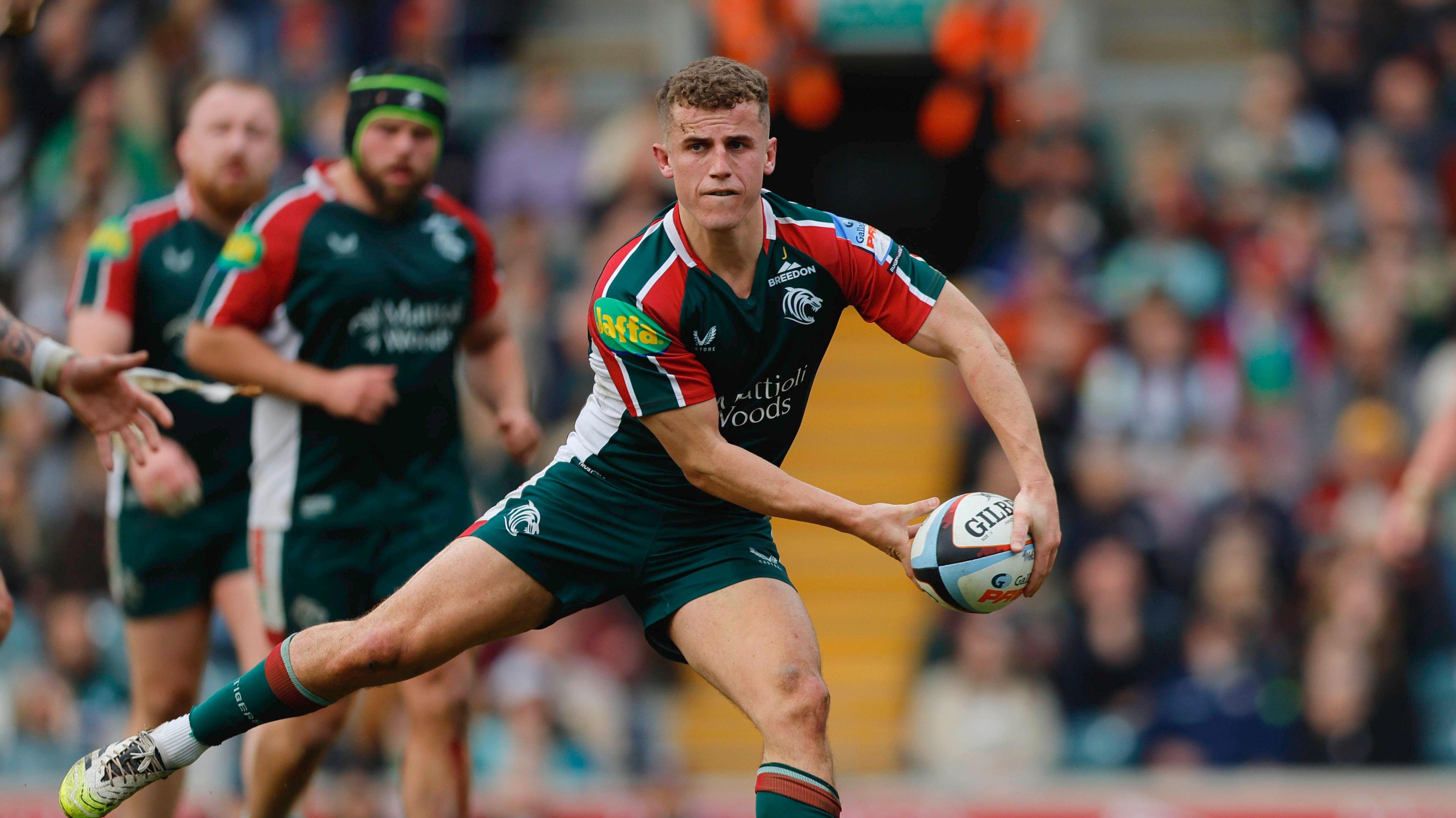 Billy Searle in action during a game with players and the crowd in the background.