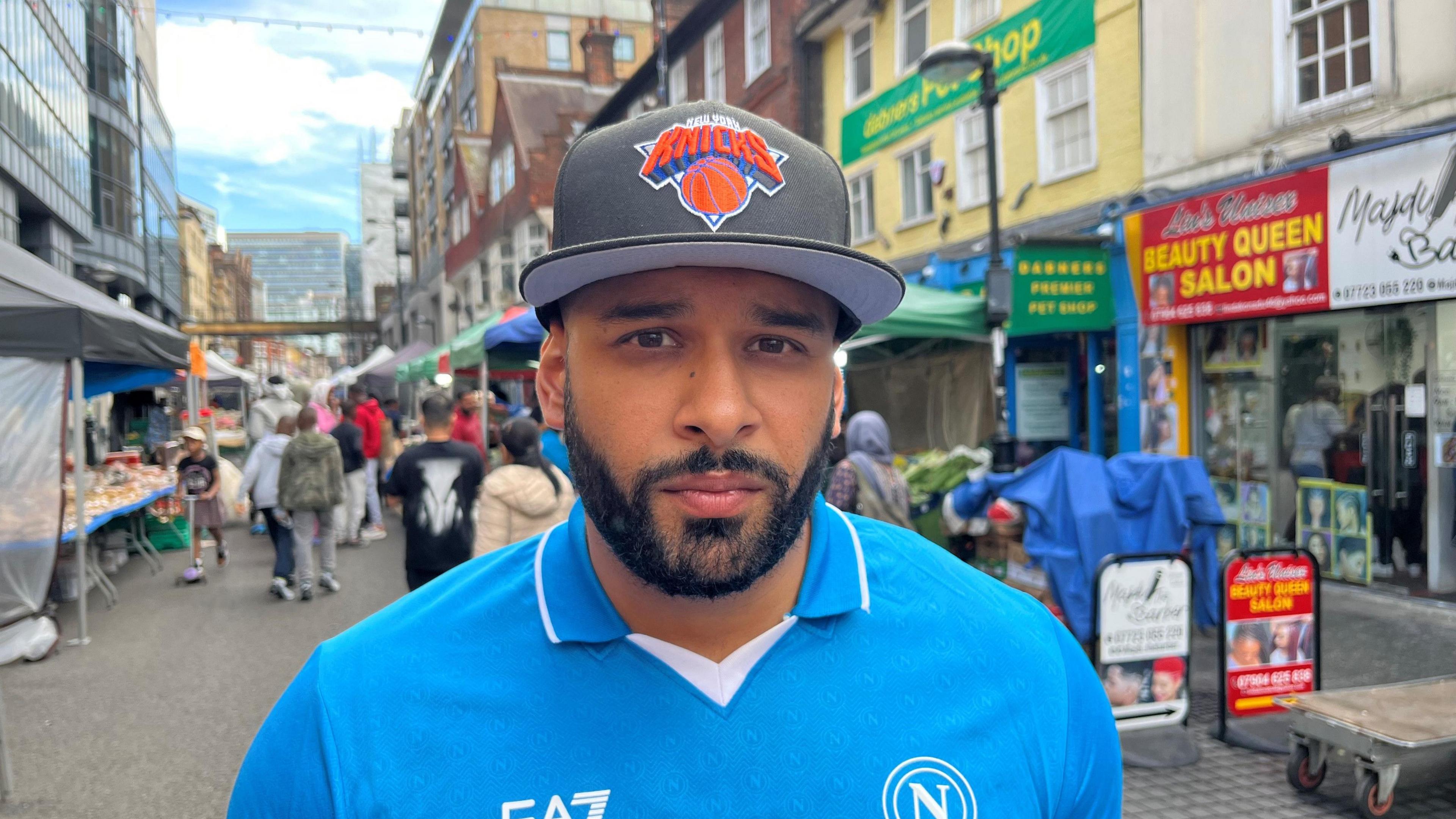 Head and shoulders shot of Croydon resident Yogendra Patel looking at the camera, standing in Surrey Street Market