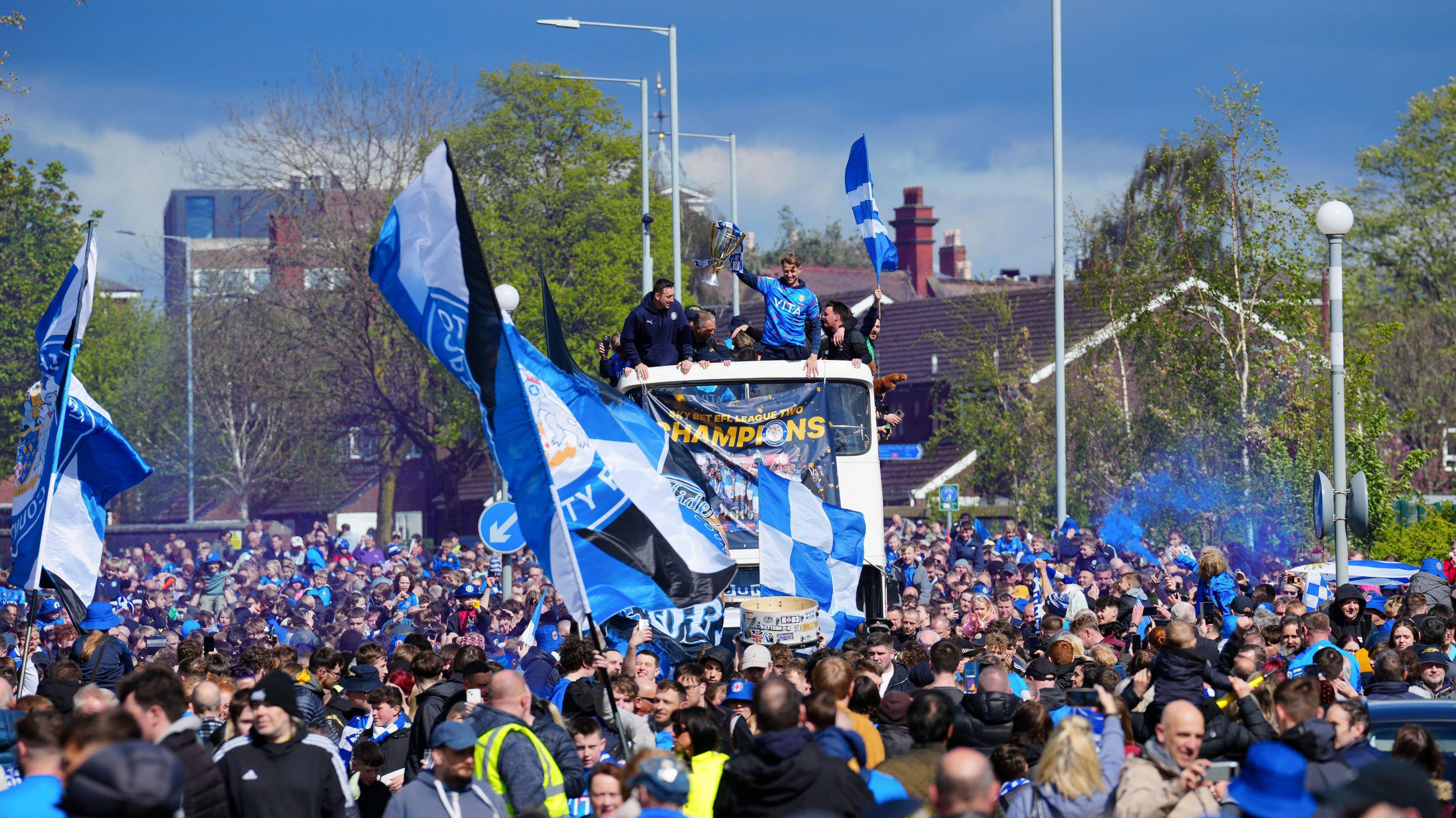 Stockport County Players and fans celebrate during an open-top bus parade in Stockport to celebrate winning the Sky Bet League Two title