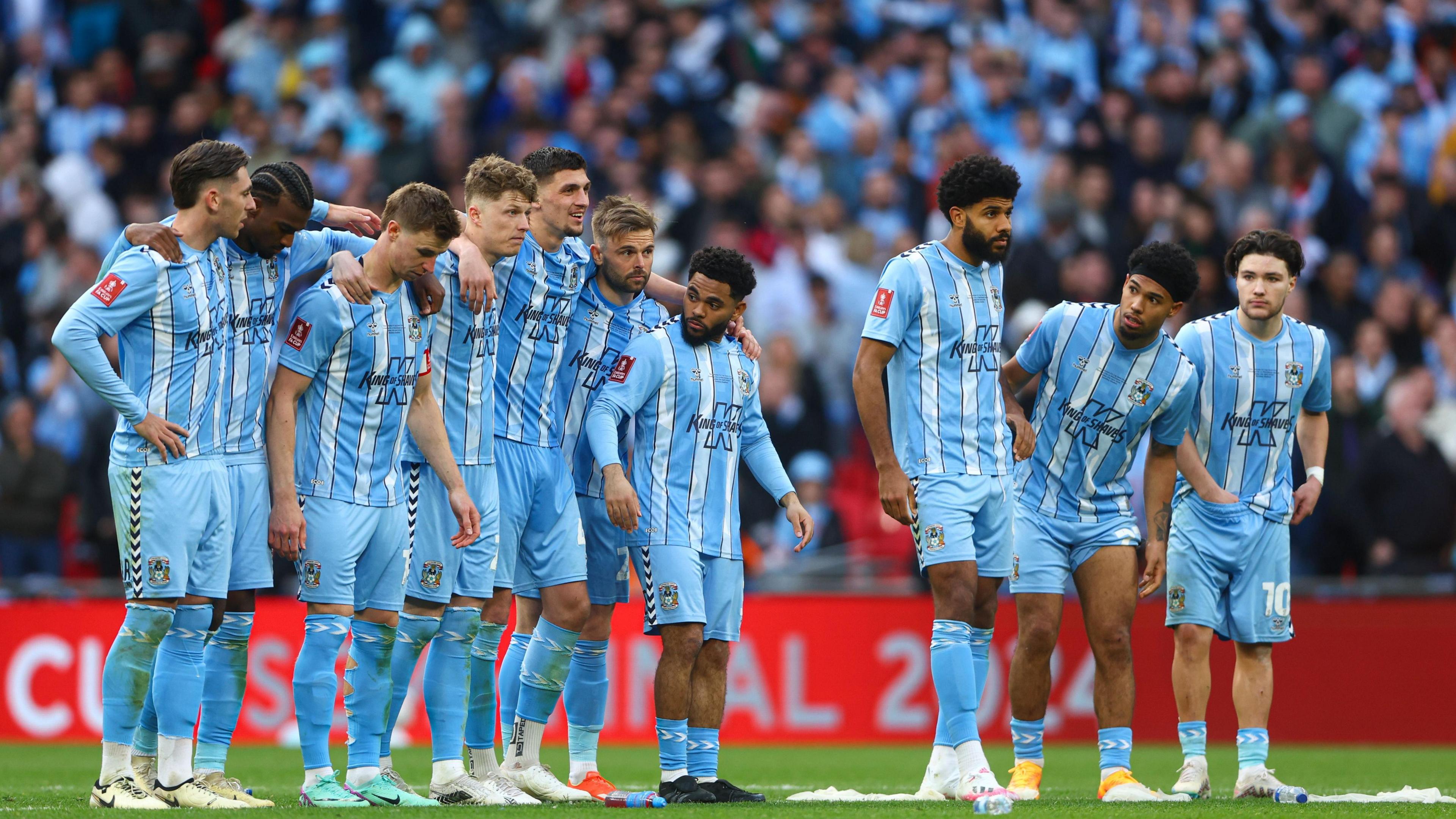 Coventry players watching the FA Cup semi-final penalty shootout in 2024