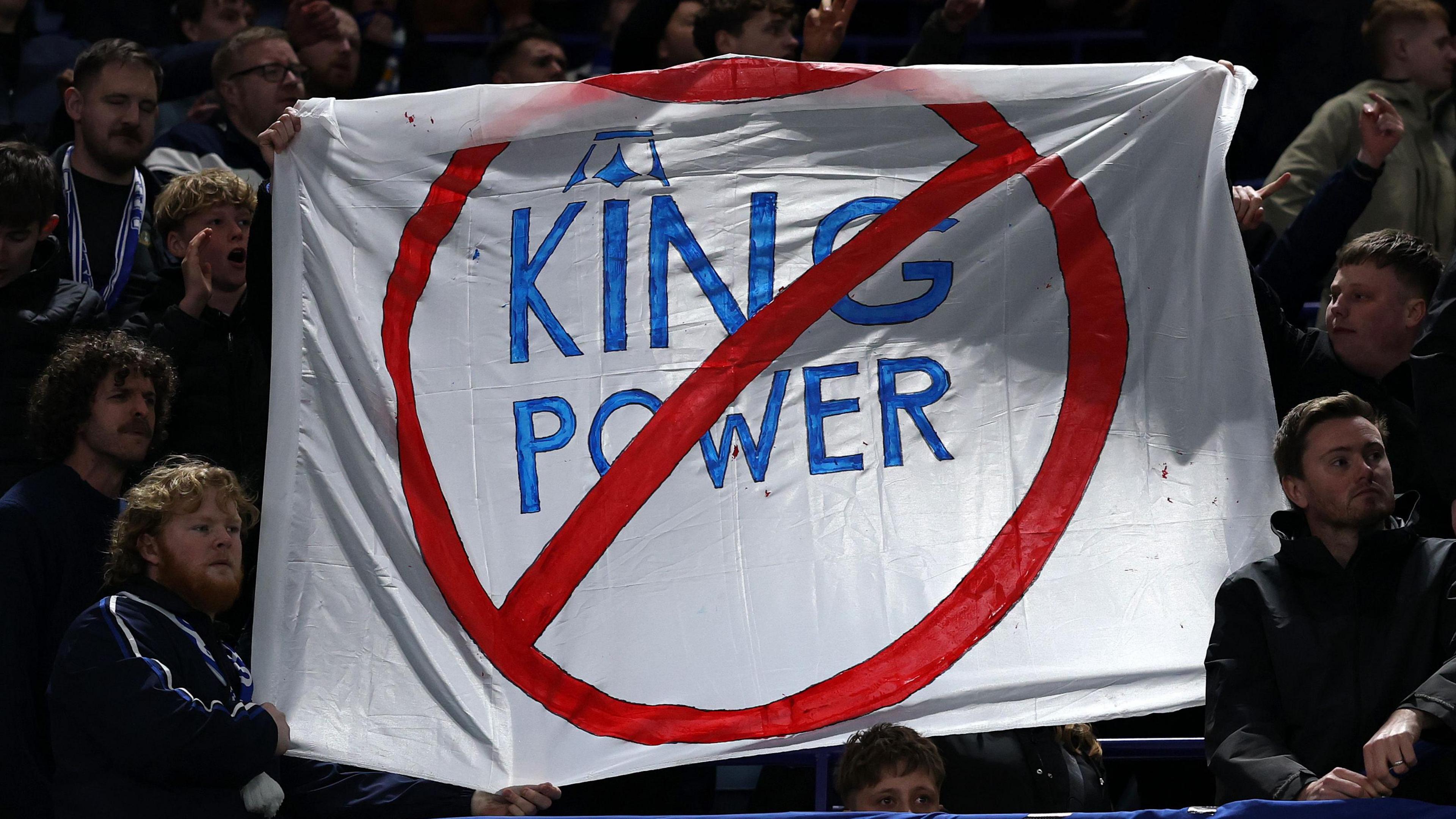 A sign is held by some Leicester City fans in protest of the club's ownership