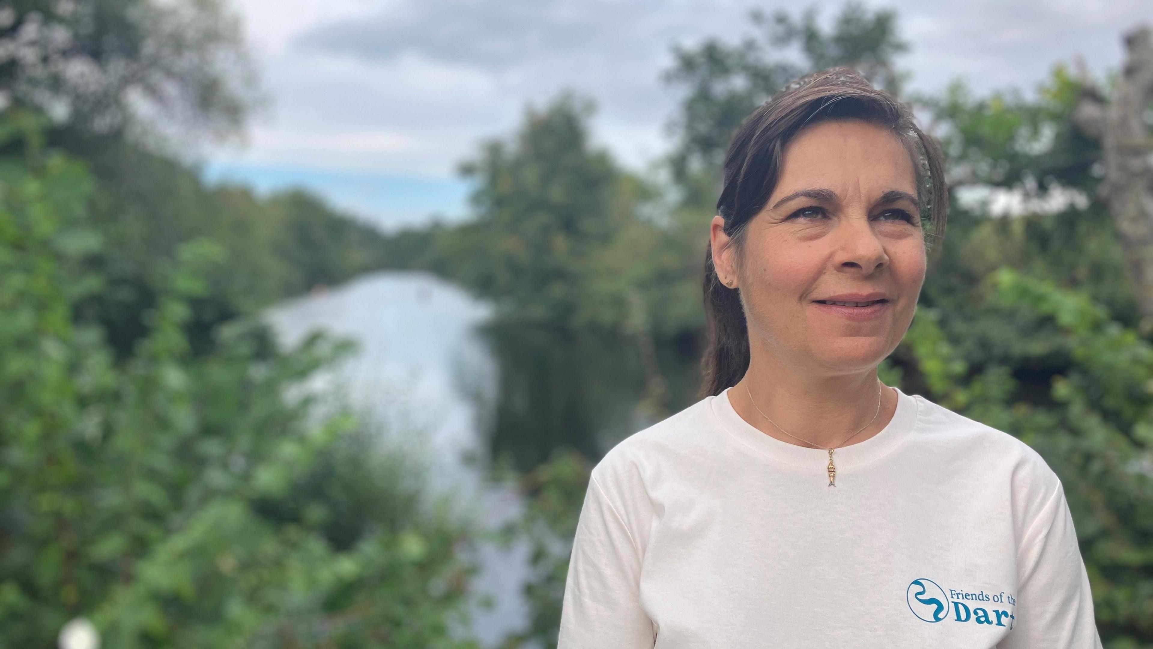 Nicky Rajska from Friends of the Dart stands in front of the River Dart in Totnes 