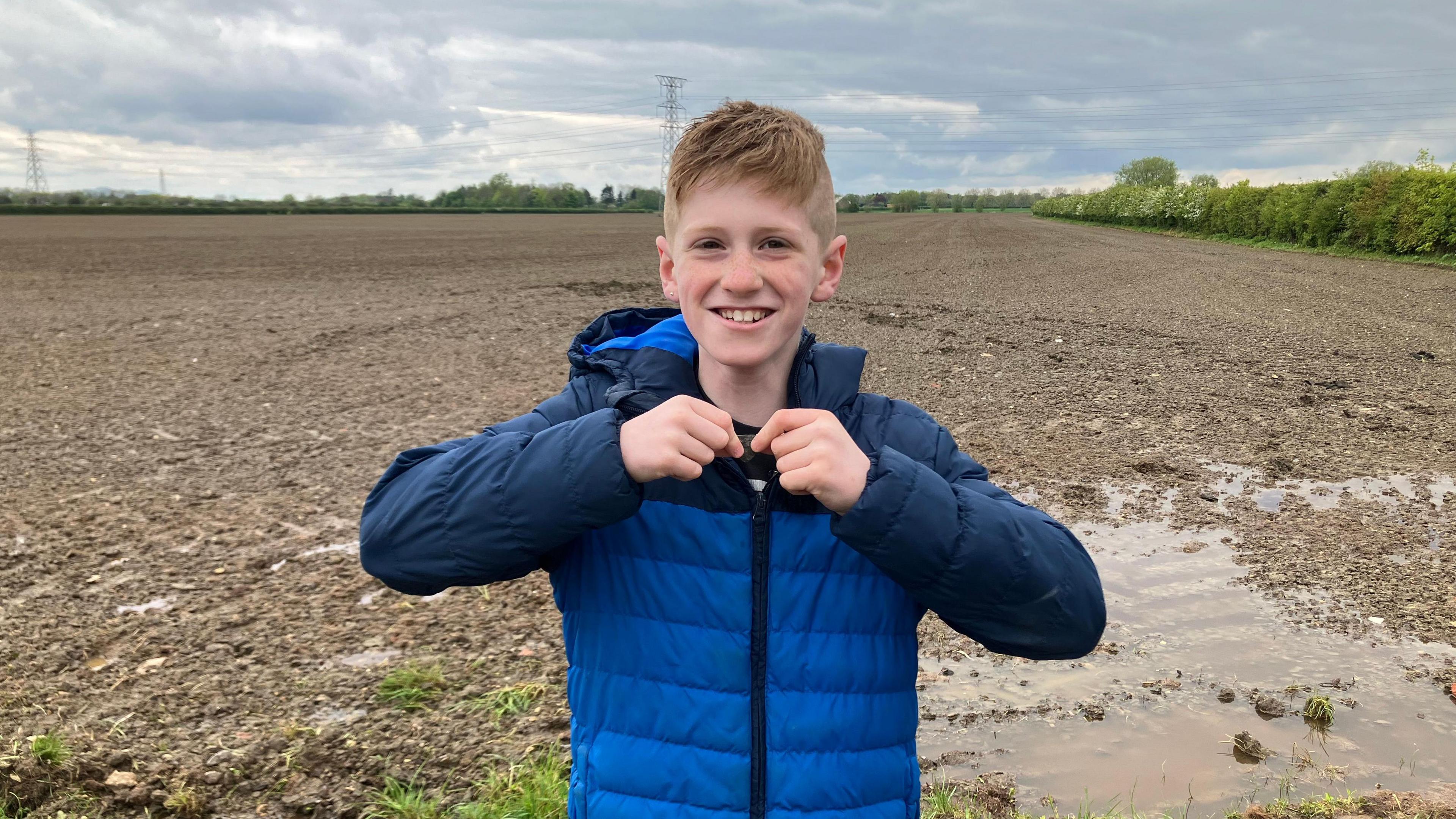 Brodie holds up the 14th Century seal to the camera