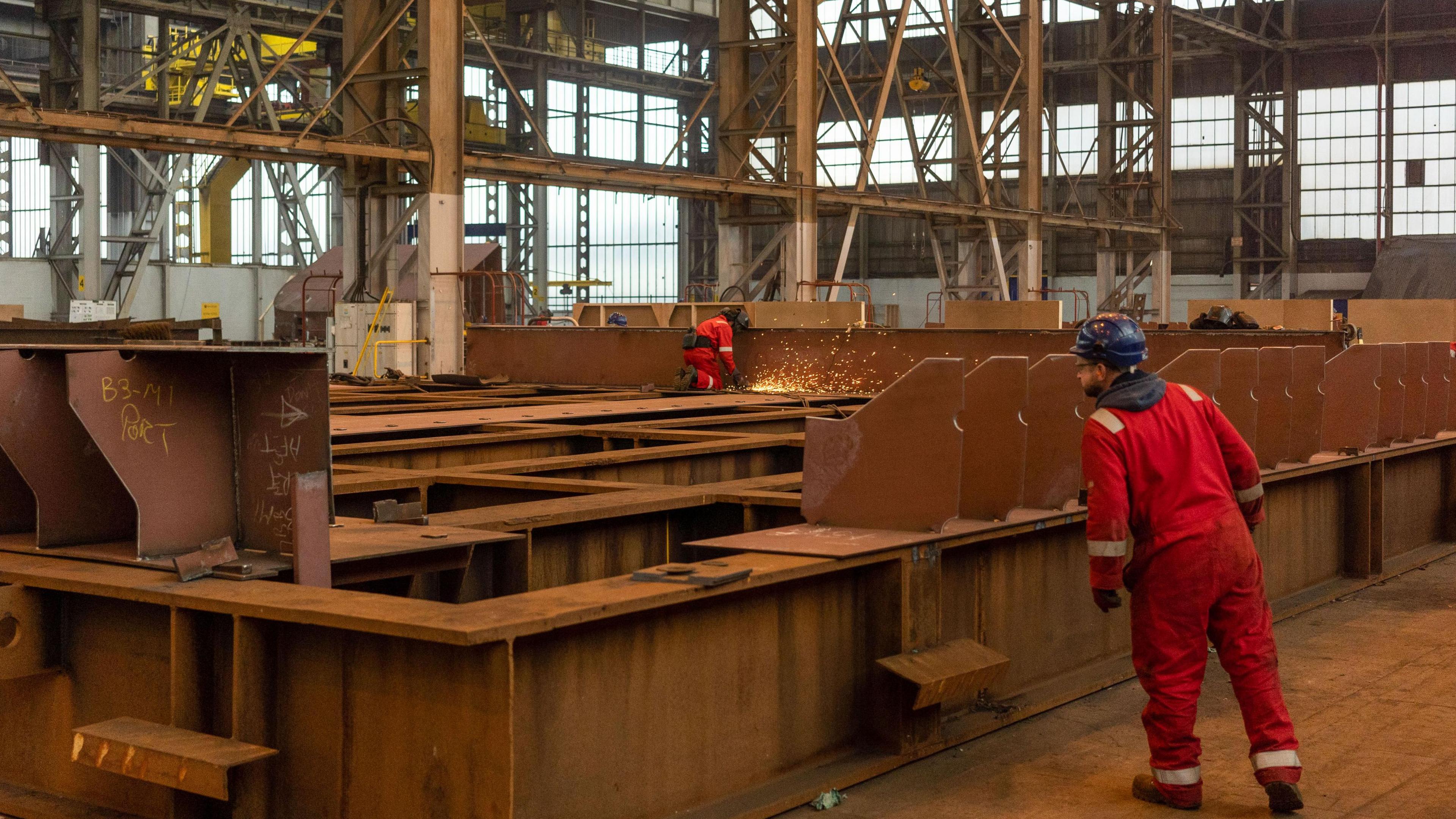 A worker grinds pieces of steel during the construction of a barge at the production facility in Harland & Wolff in Belfast.