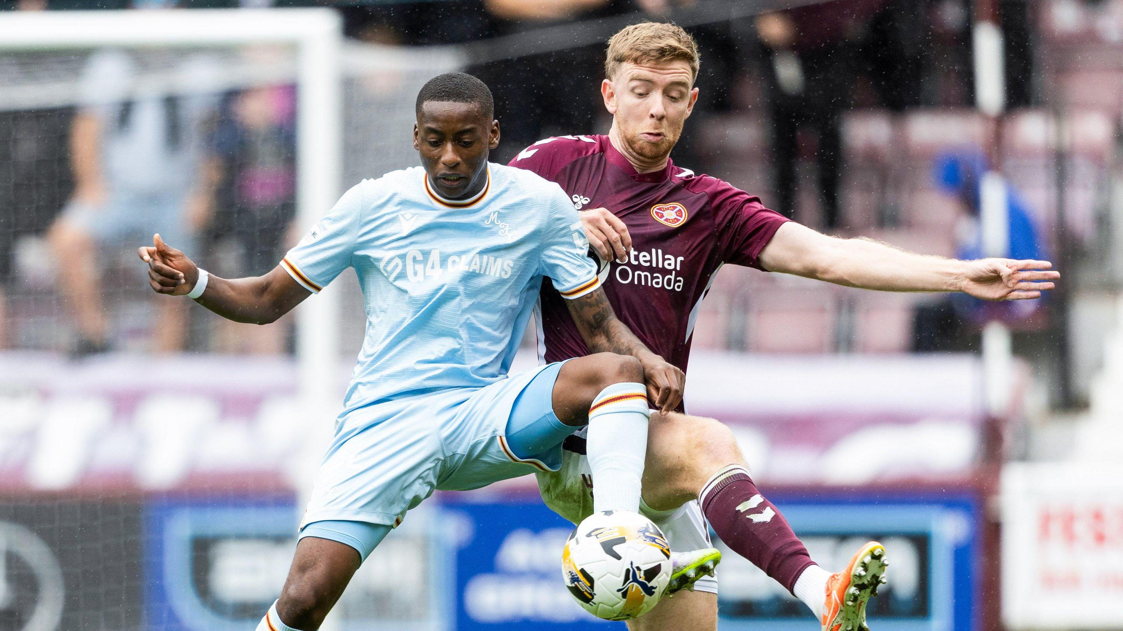 Tawanda Maswanhise and Stuart Findlay battle for possession