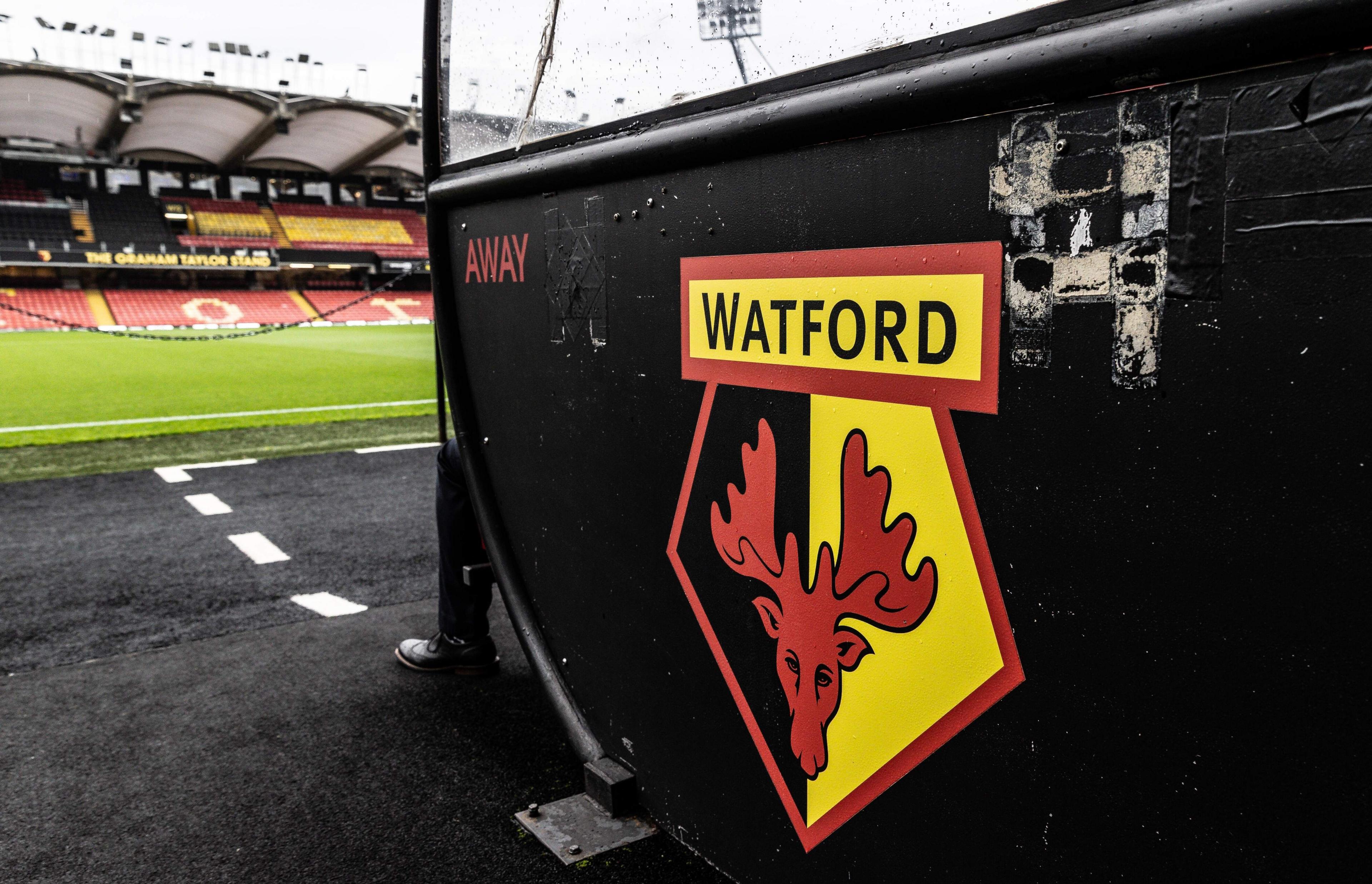 Watford FC crest on a small black brick wall inside Vicarage Road stadium