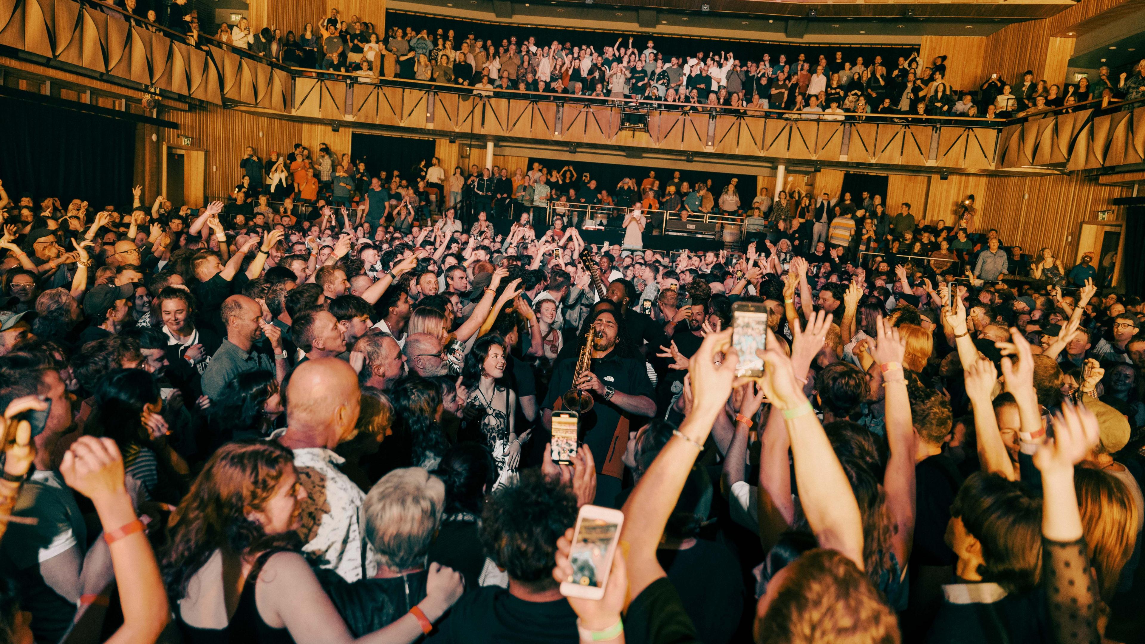 Ezra Collective saxophonist playing in the crowd of its gig at the Bristol Beacon.